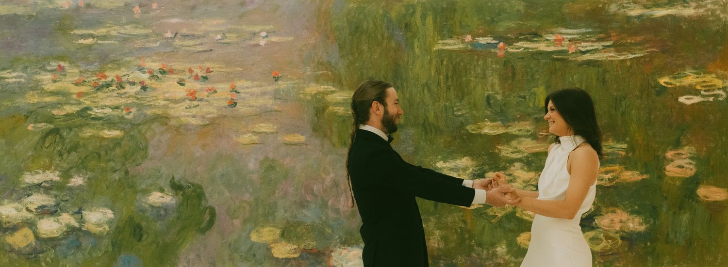 couple standing together infront of a dreamy garden monet painting with water lilies at carnegie museum of art .