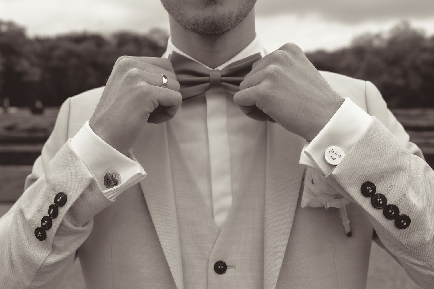 Detail shots of formal white wedding attire and bow tie adjustments.