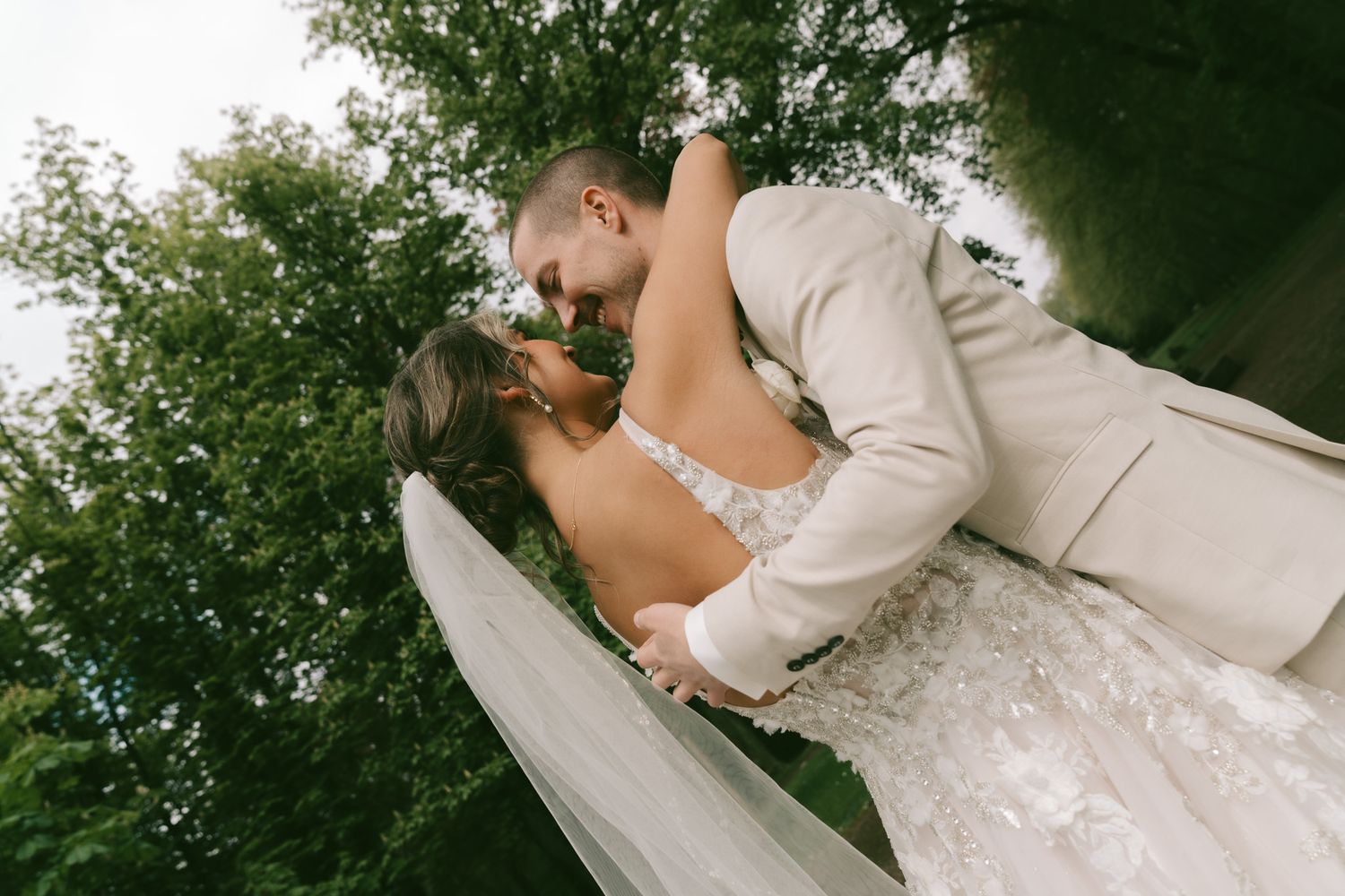 A romantic outdoor wedding portrait with a couple in cream and white attire in Germany.