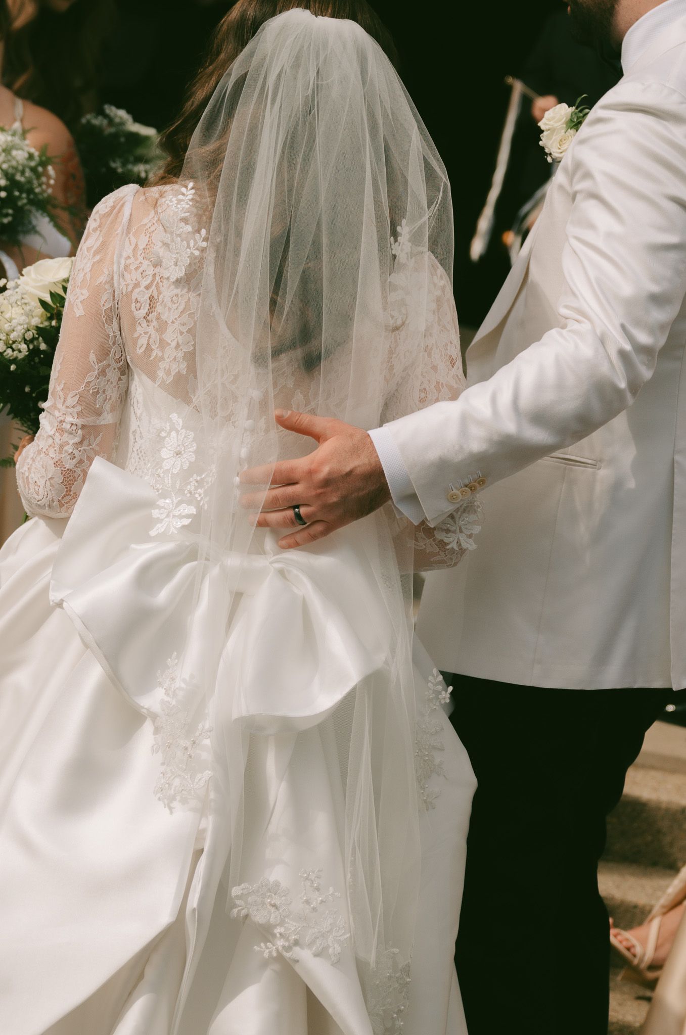 Close-up of intricate lace wedding dress details and flowing veil in downtown pittsburgh, pa.