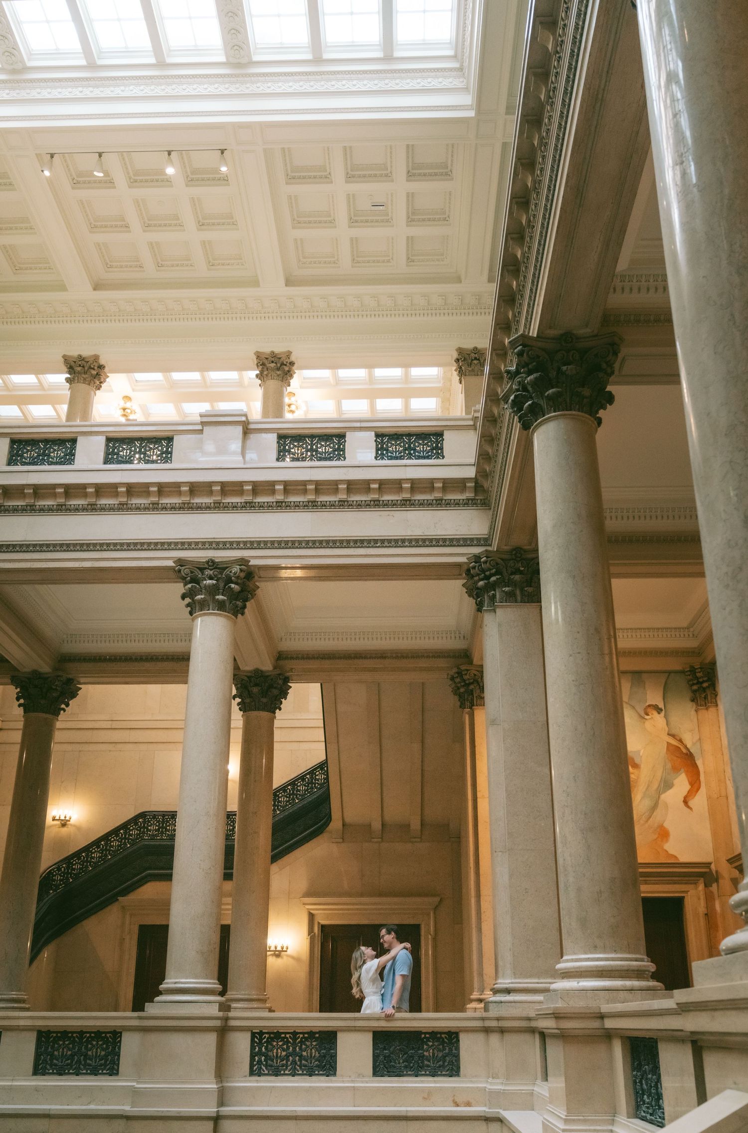 Elegant interior architecture featuring white columns and a glass ceiling in a historic building.