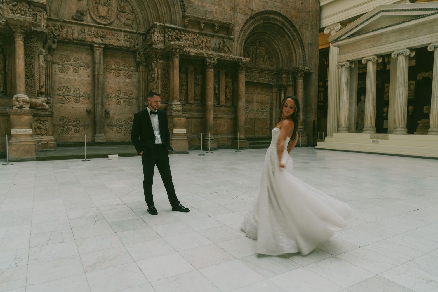 Elegant couple shares a romantic moment in front of ornate classical architecture.