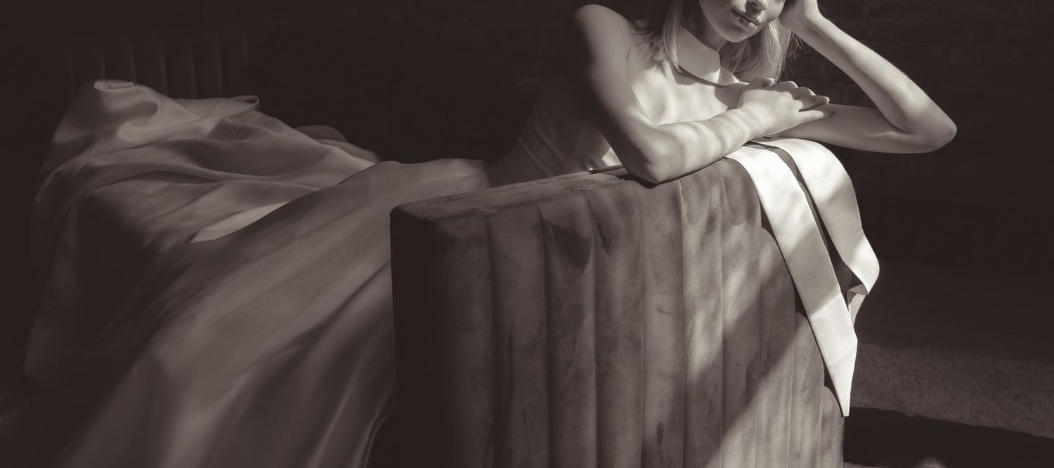 Dramatic black and white composition featuring flowing fabric and elegant posing.