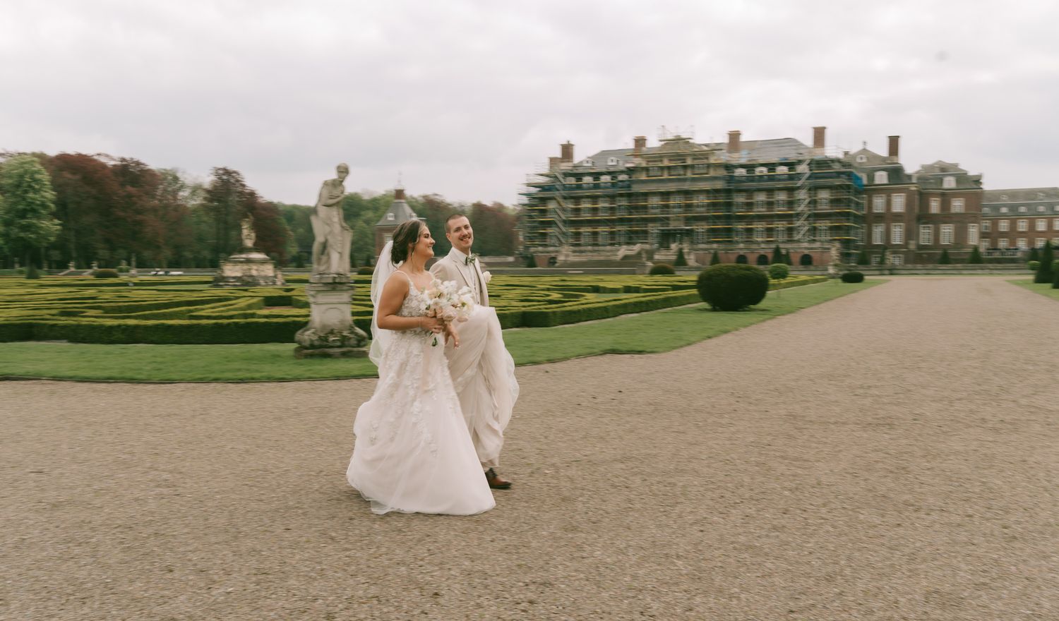 A wedding couple walking across a grand estate garden in Germany at a Castle.