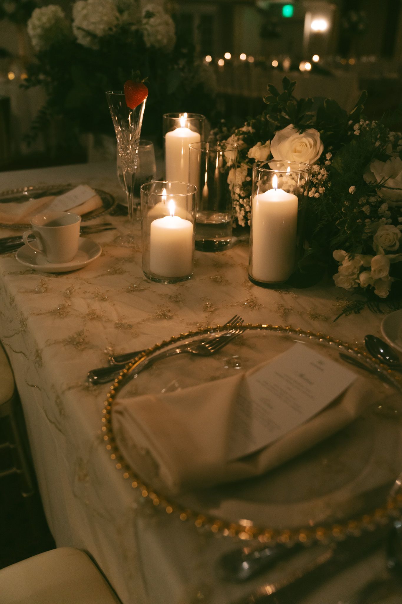 Romantic wedding reception table setting with glowing candles, flowers, and gold-rimmed plates in downtown pittsburgh, pa.