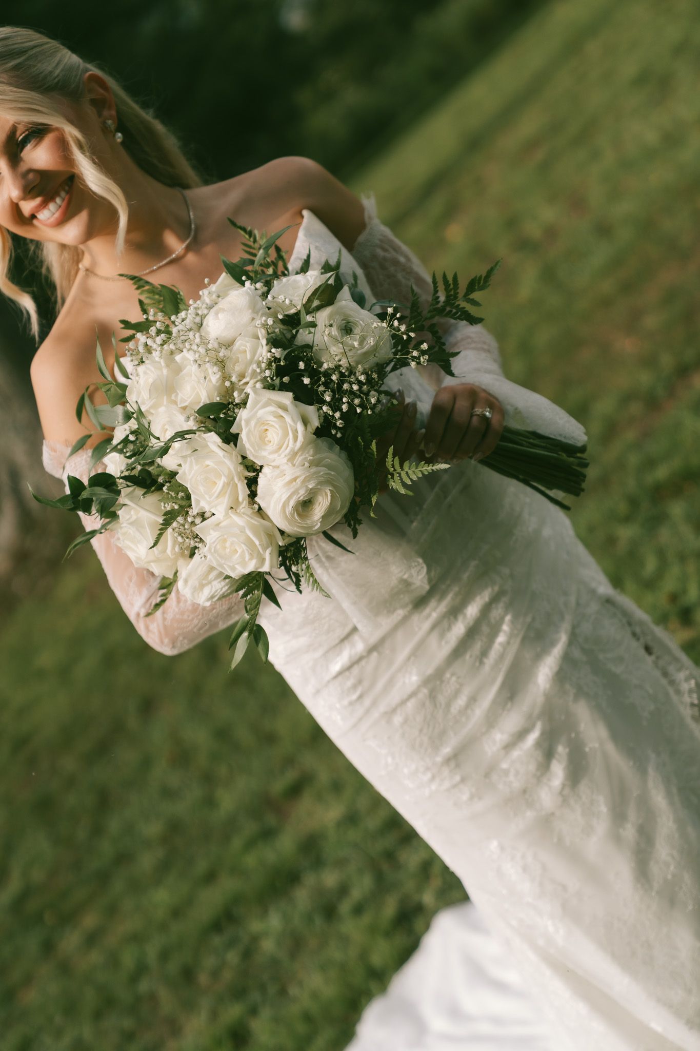 Close-up view of white roses and baby's breath flowers in an elegant wedding bouquet against lush green grass in isle of skye scotland