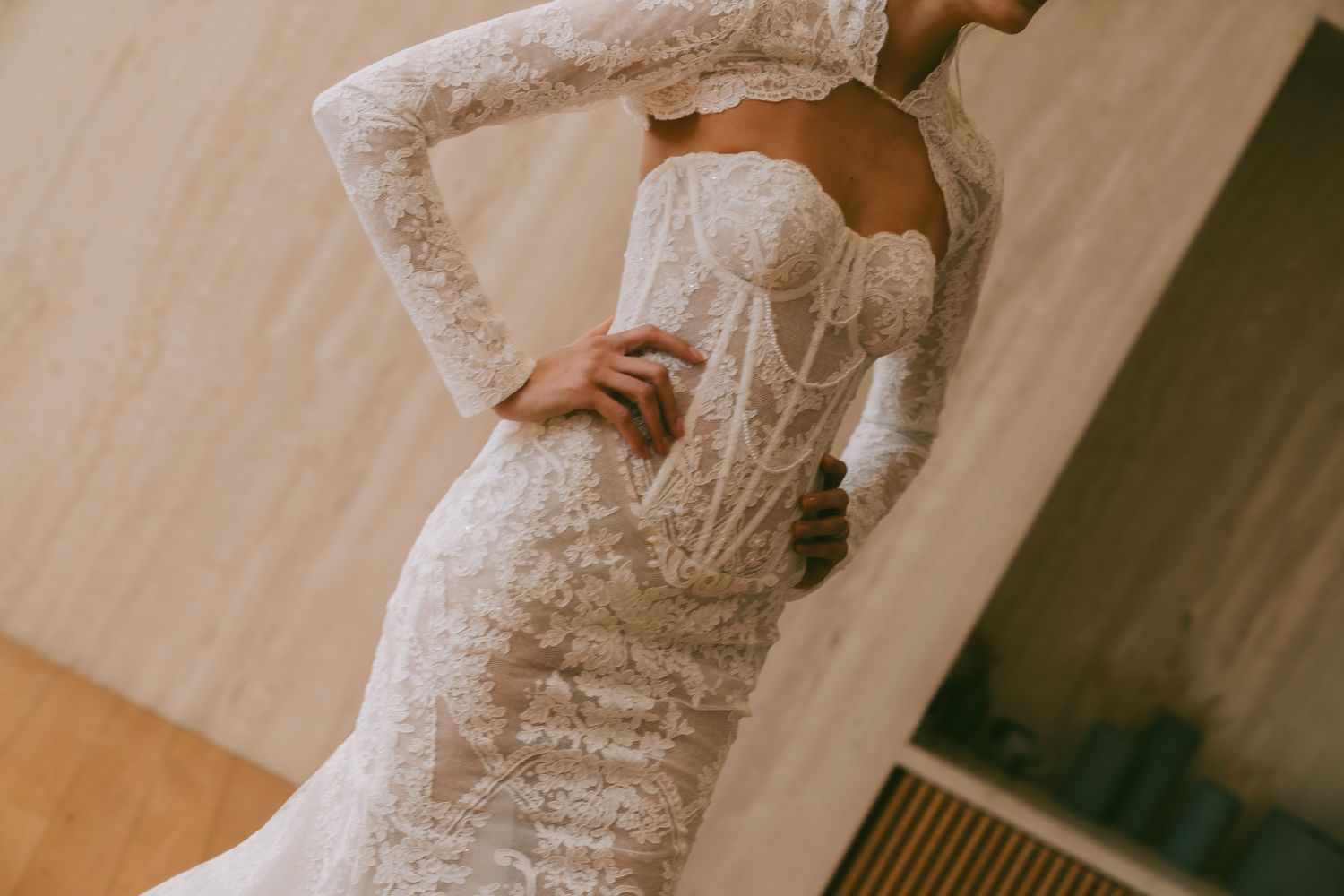 Eden Aharon Fitted lace wedding gown with intricate detailing and long sleeves photographed in natural light.