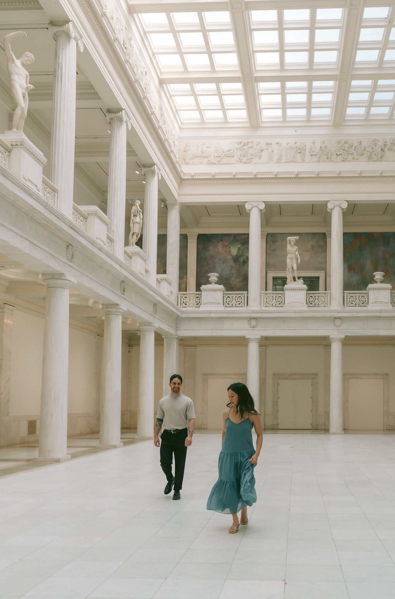 Minimalist architectural wedding photoshoot in grand white room with skylights.