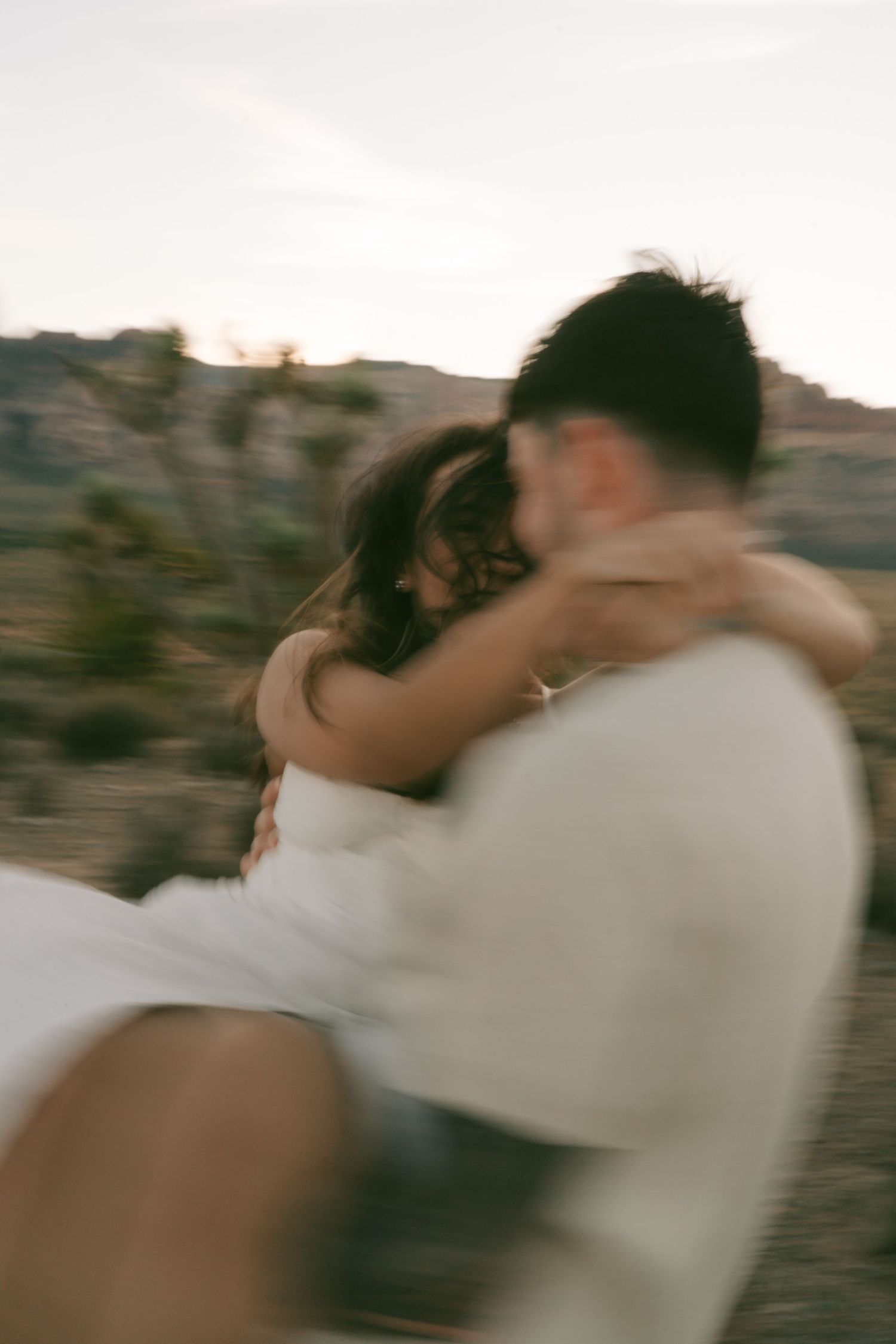 A romantic dance moment captured in soft focus against a desert landscape at dusk in Las Vegas NV.