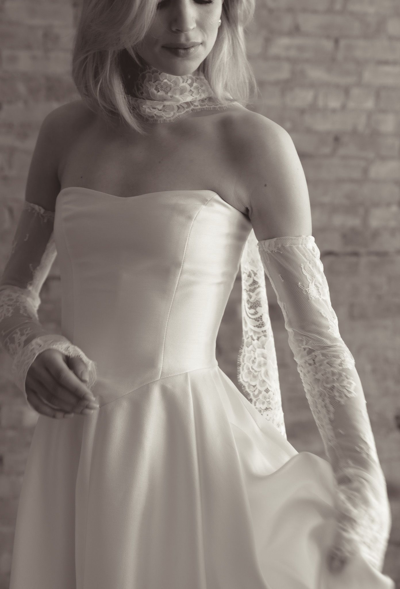 Close-up details of a strapless white House of Flora wedding dress with delicate lace sleeves and elegant fabric in New York City