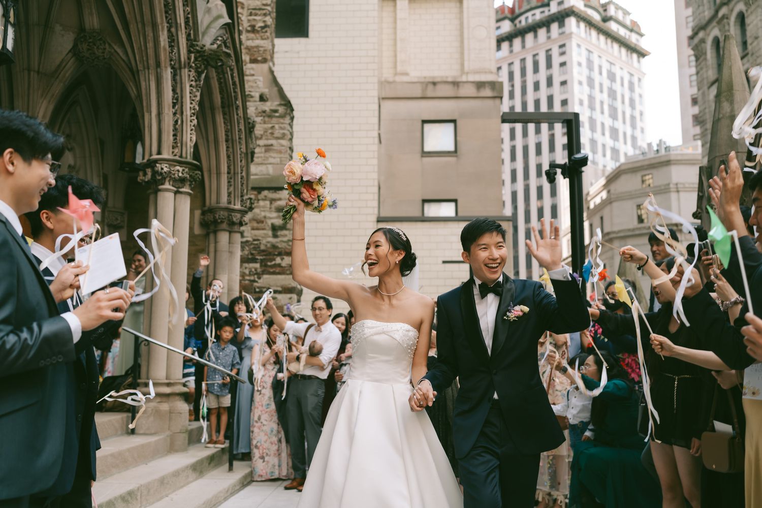 Wedding party celebration outside a historic cathedral with guests blowing bubbles in Downtown Pittsburgh, PA.