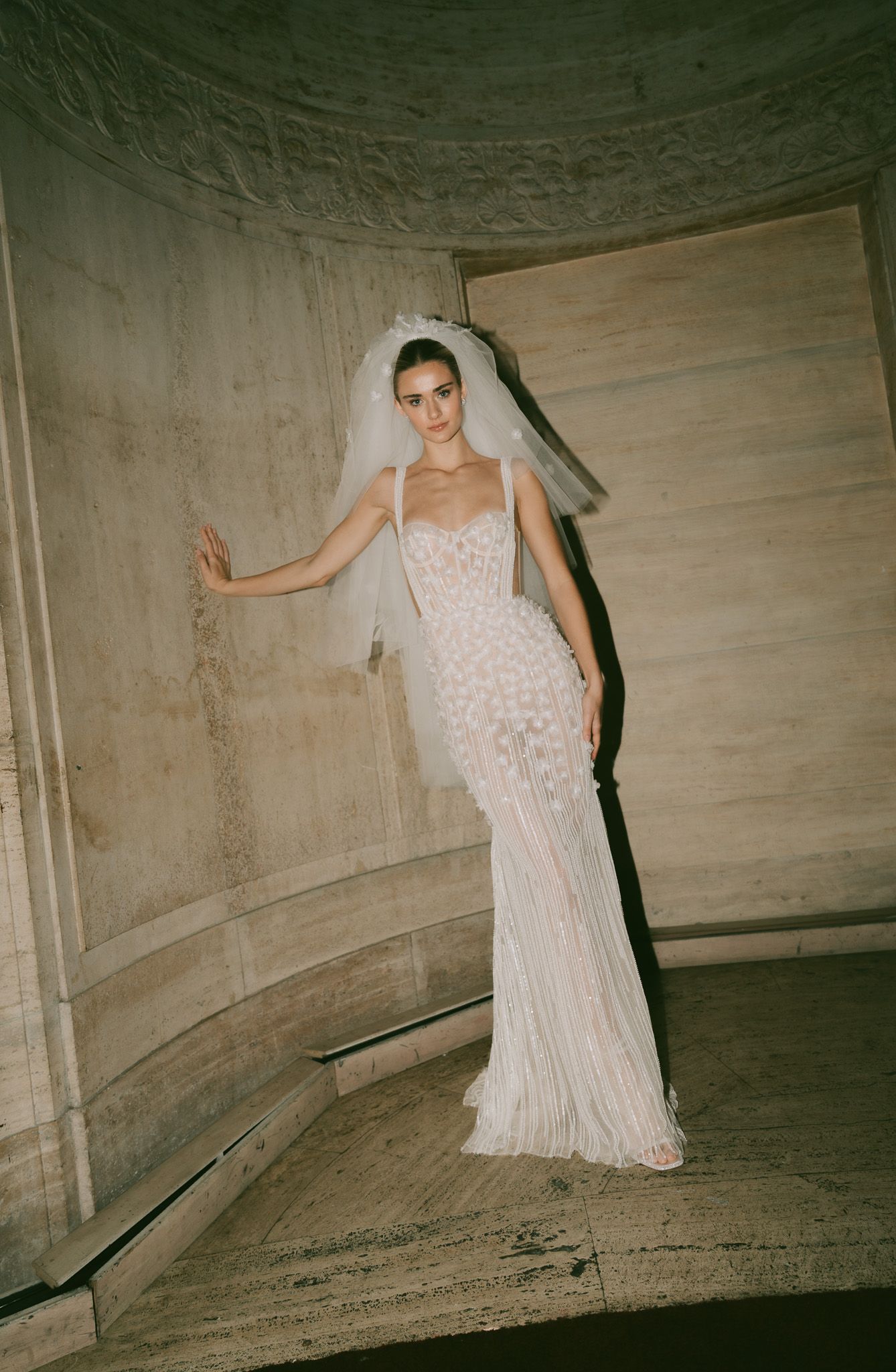 Sleek Berta mermaid wedding dress with spaghetti straps and beaded details in a romantic setting.