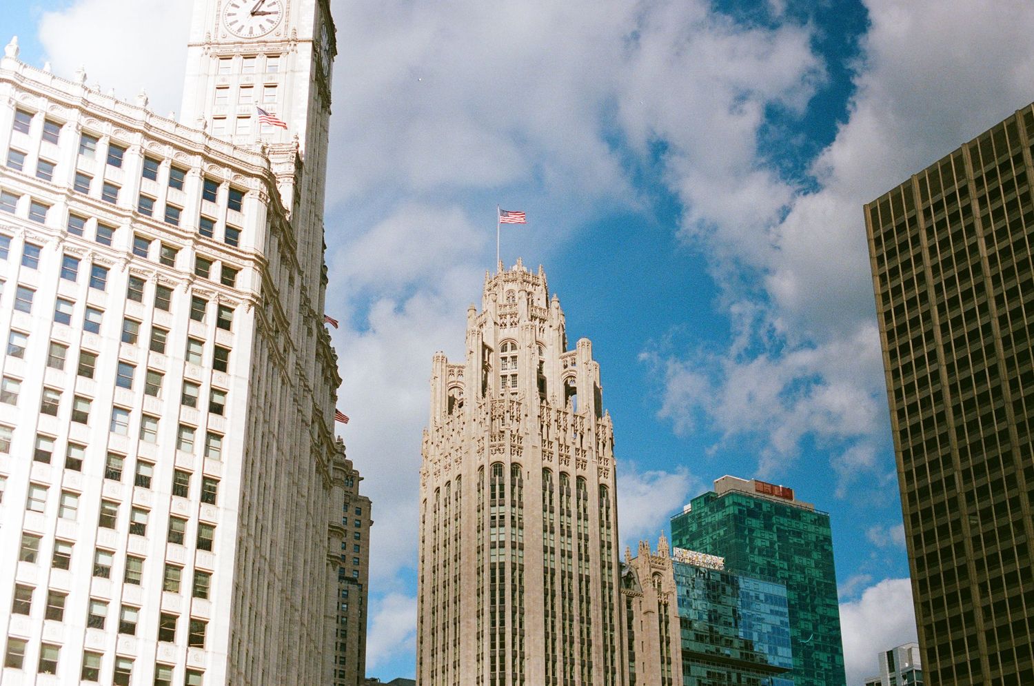 Gothic-style Tribune Tower rises against blue sky with white clouds in downtown Chicago.