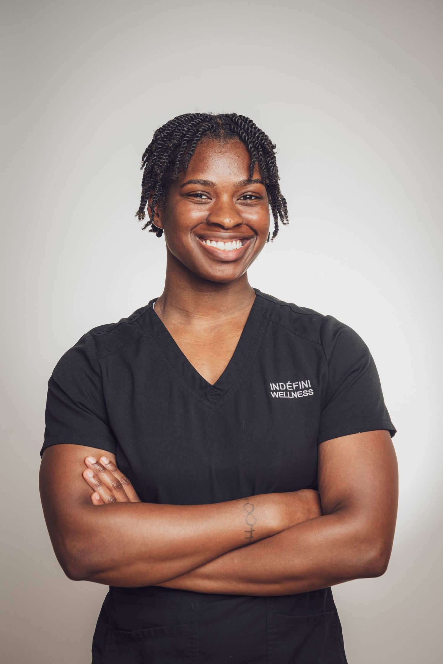 Healthcare professional in black scrubs posing against neutral background. goose.img photography LLC - Chicago Photographer