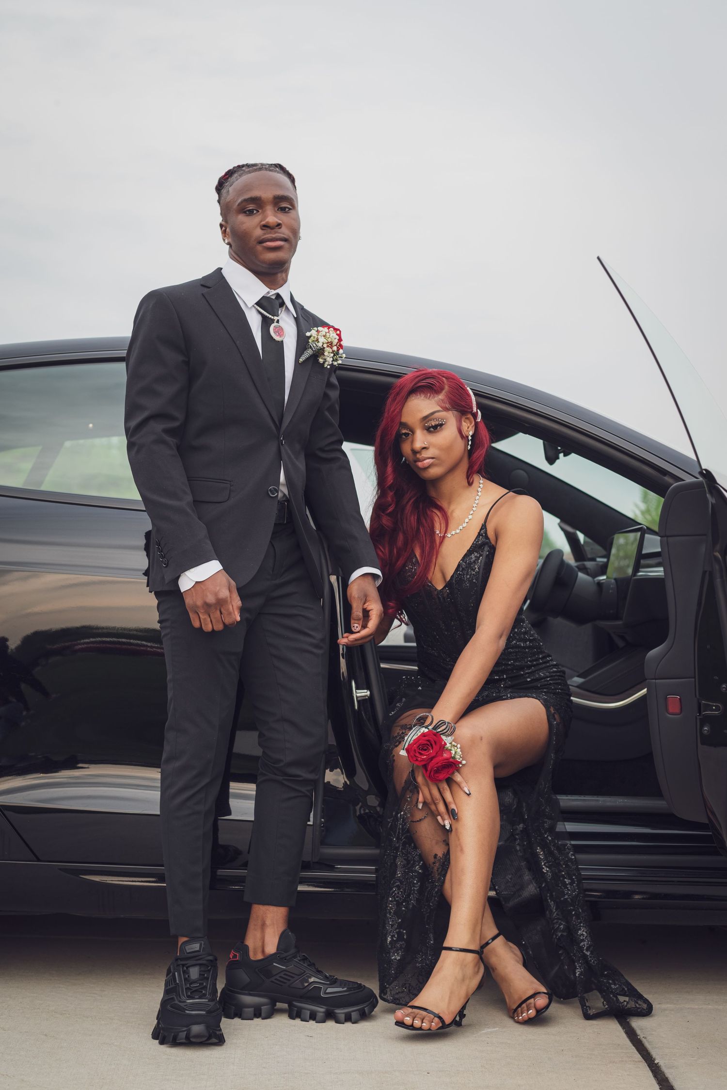 A formal couple poses next to a black car dressed for a special occasion. goose.img photography LLC - Chicago Photographer