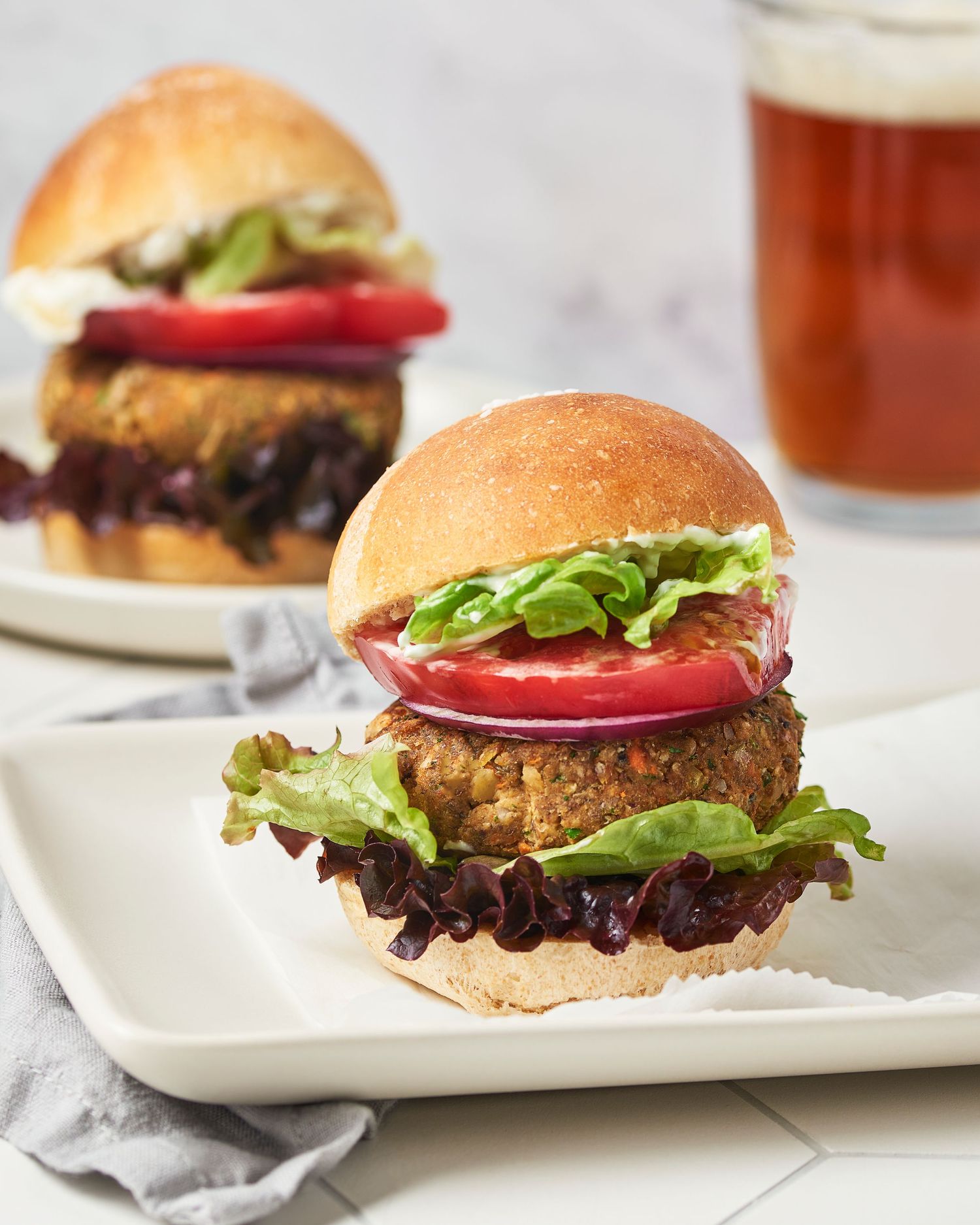 Gourmet veggie burger with lettuce, tomato and bun served with craft beer.