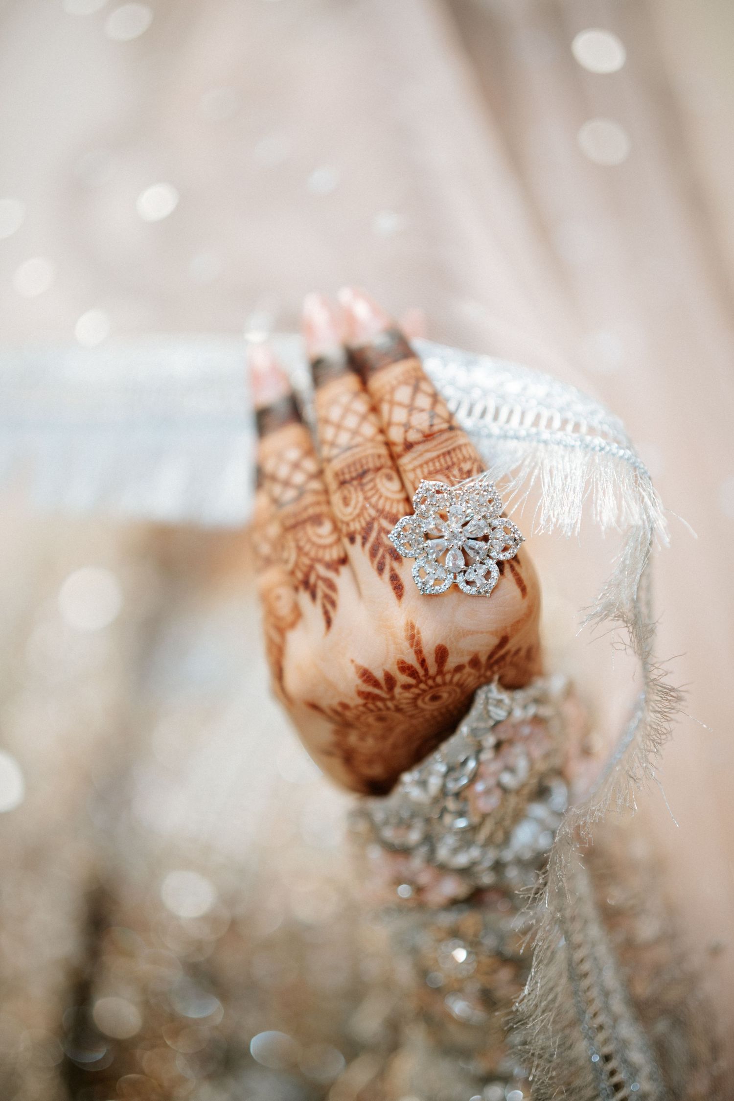 Toronto Muslim wedding photographer captures a bride’s hand adorned with intricate henna designs and a sparkling diamond ring