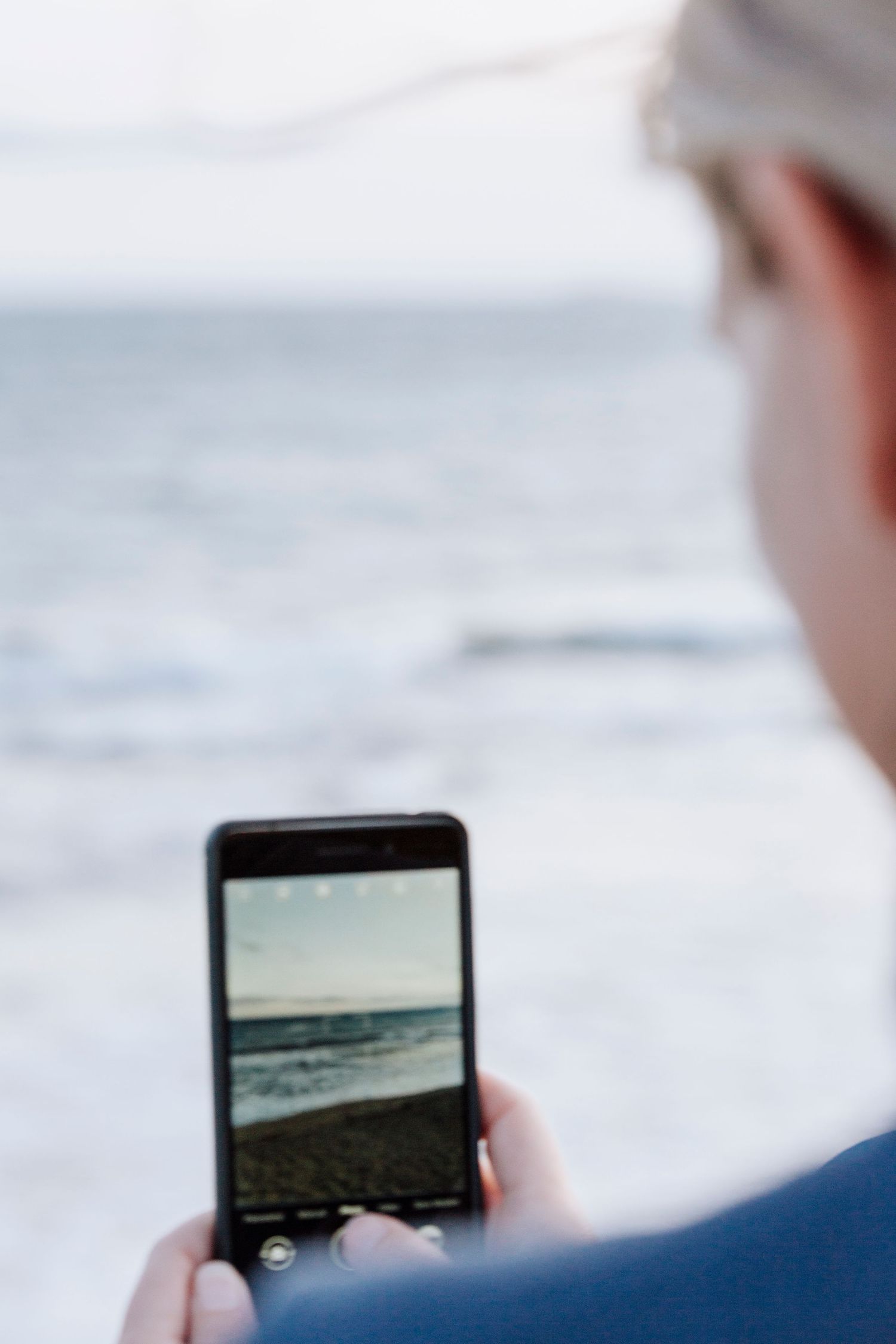 Woman photographing the sea with her phone on YORKE PENINSULA