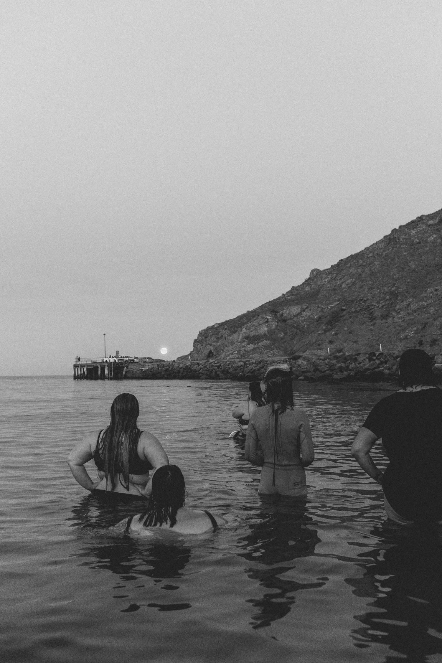 Women in water watching blood moon rise