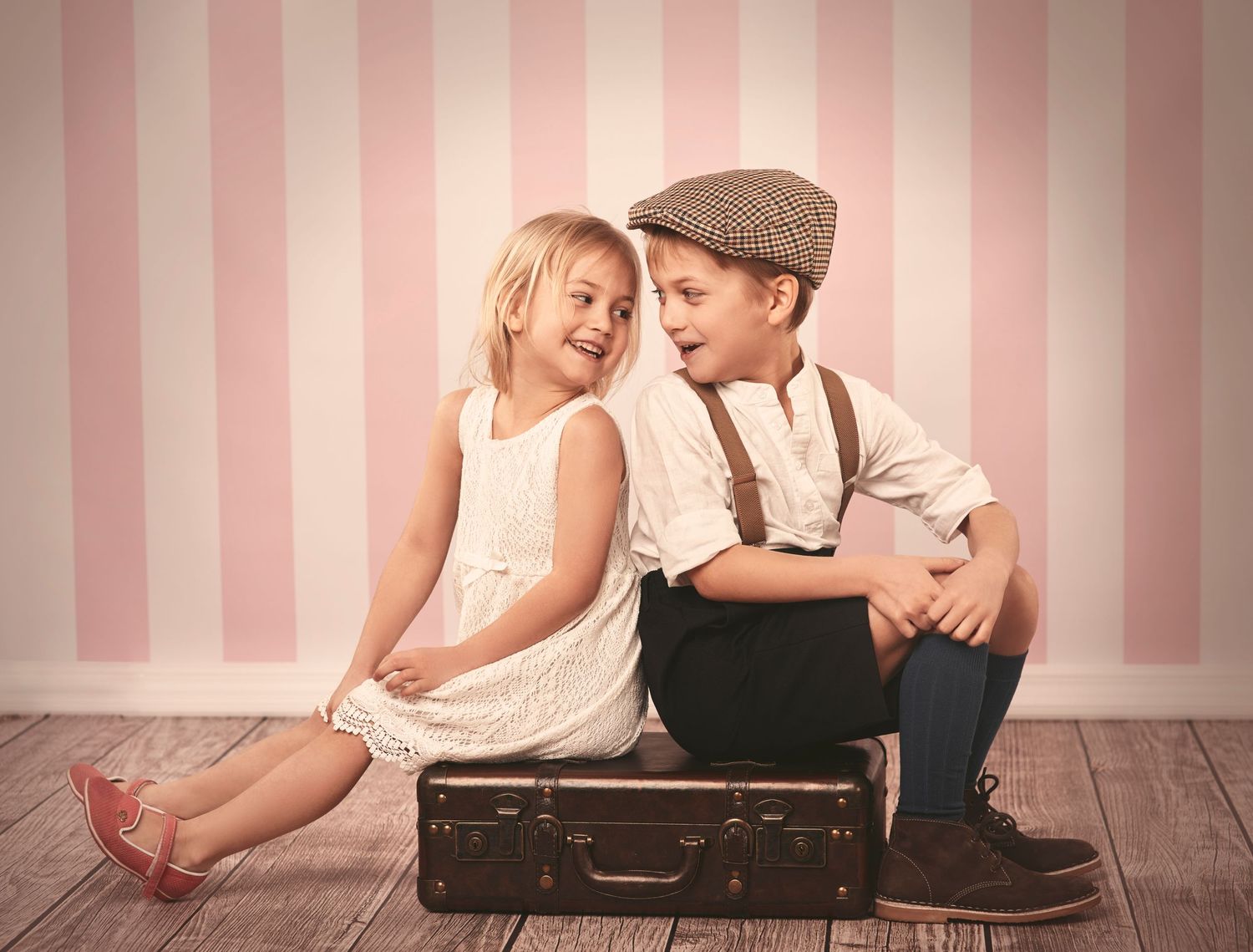 Romantic vintage-themed photo shoot with soft pink striped wallpaper background.