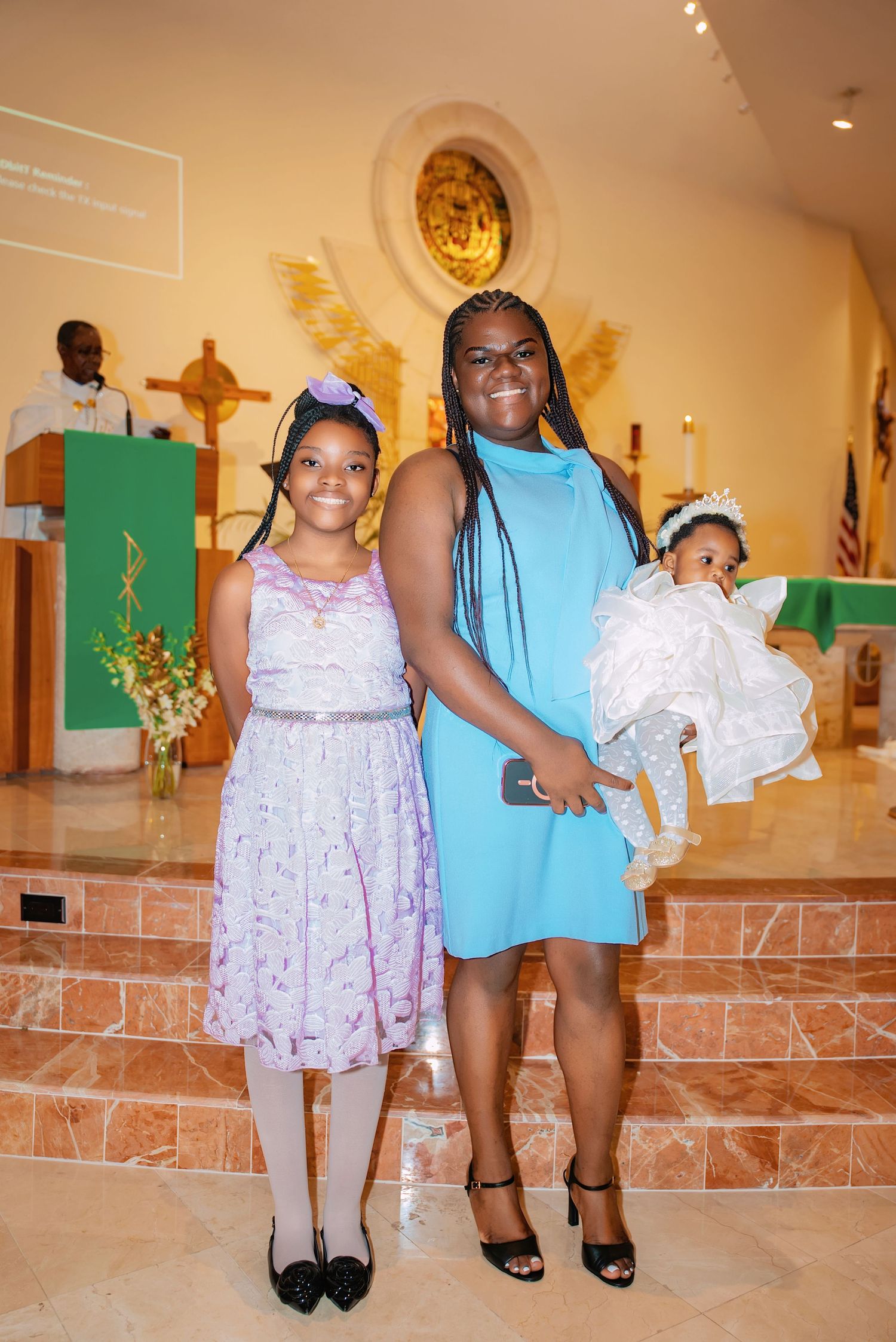People in summer dresses and formal wear standing together in a church interior.