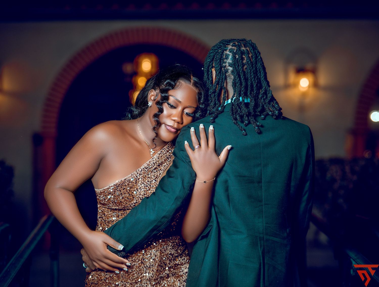 Couple in formal attire sharing intimate dance moments in dimly lit venue.
