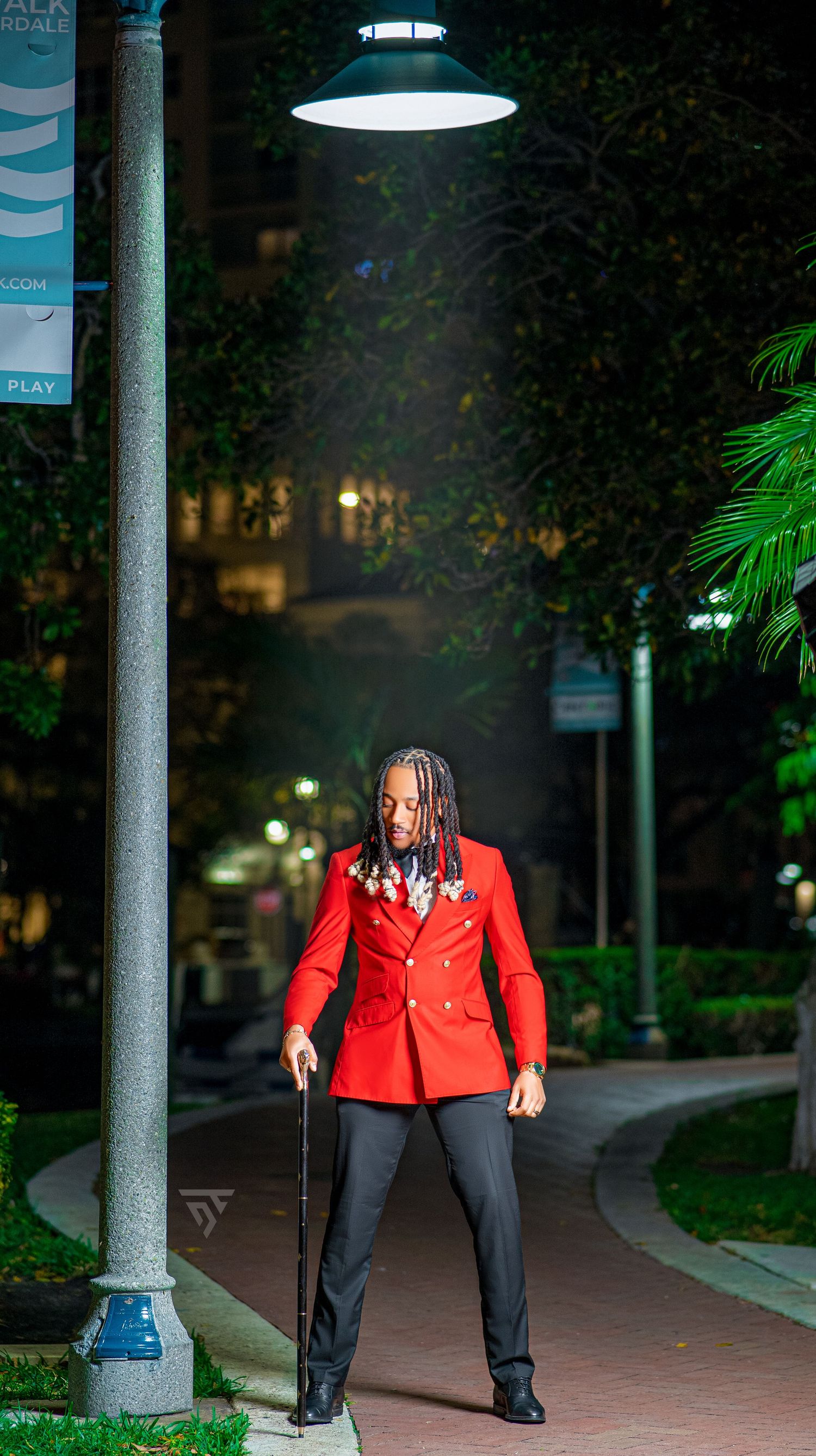 Nighttime portrait session featuring a bright red blazer and walking cane.