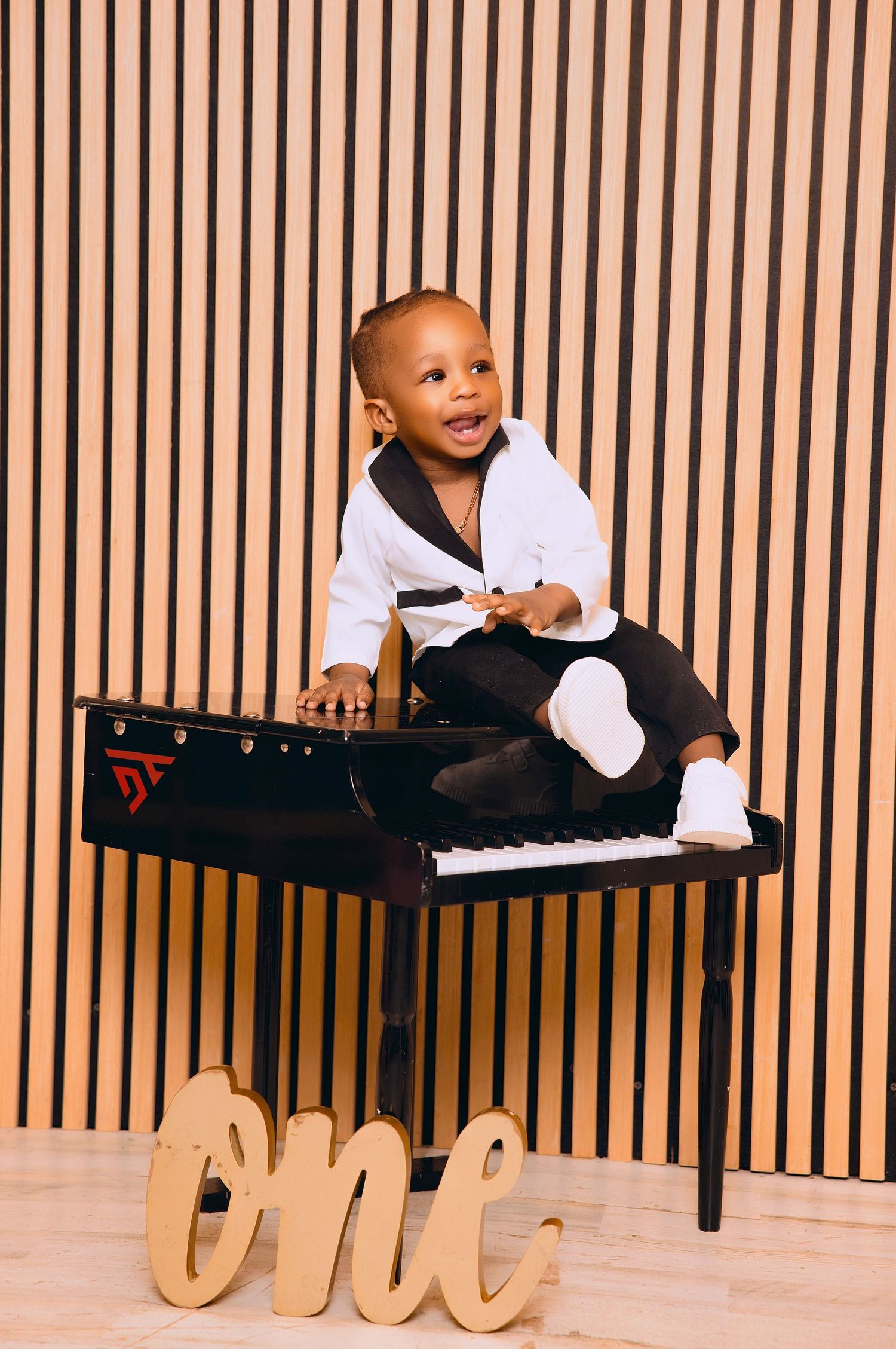 Child exploring keyboard and musical instruments in studio setting.