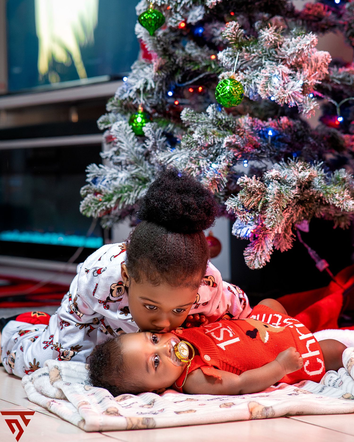 Cozy Christmas scene with snowy decorated tree branches and red holiday decor.