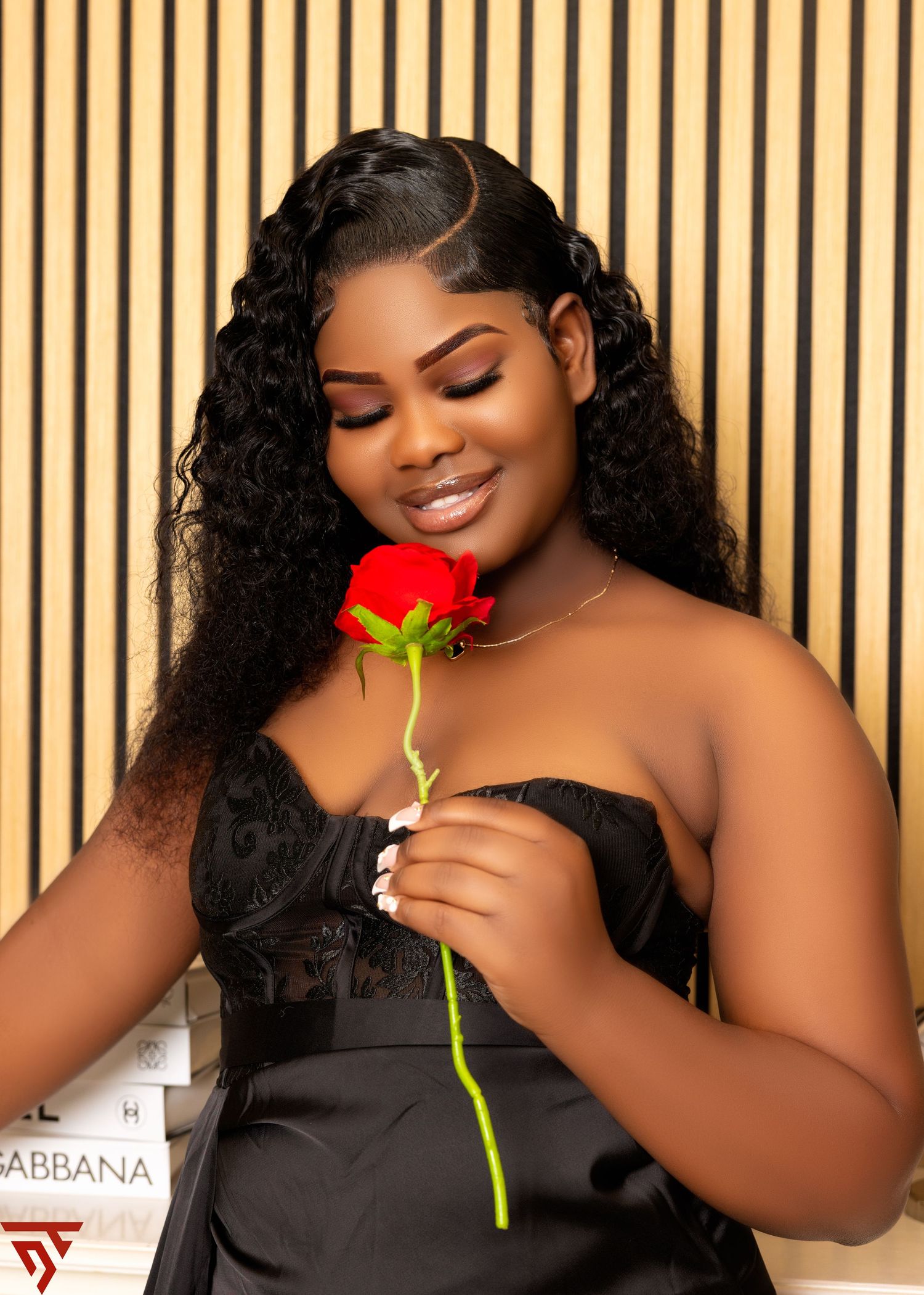 An elegant black strapless dress paired with a delicate yellow rose.