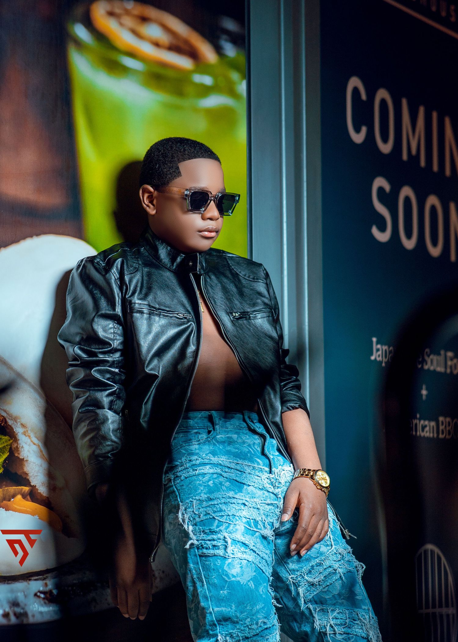 Street style fashion with distressed denim and leather jacket against urban storefront.