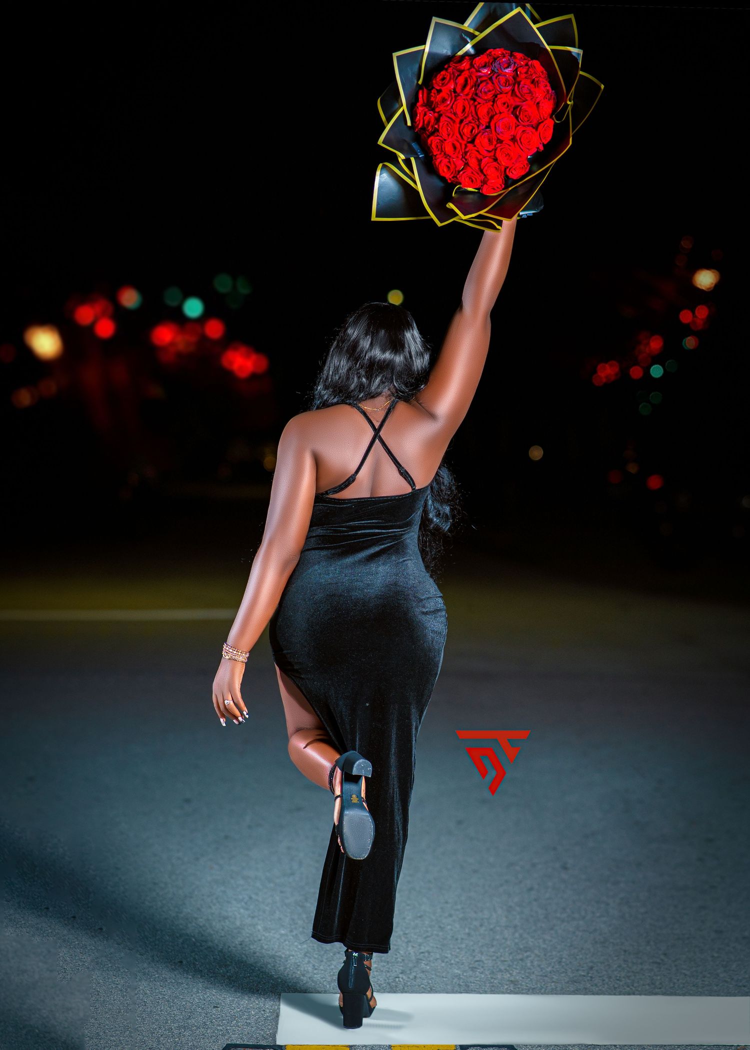 Artistic nighttime photo showing silhouette holding illuminated red geometric decoration.