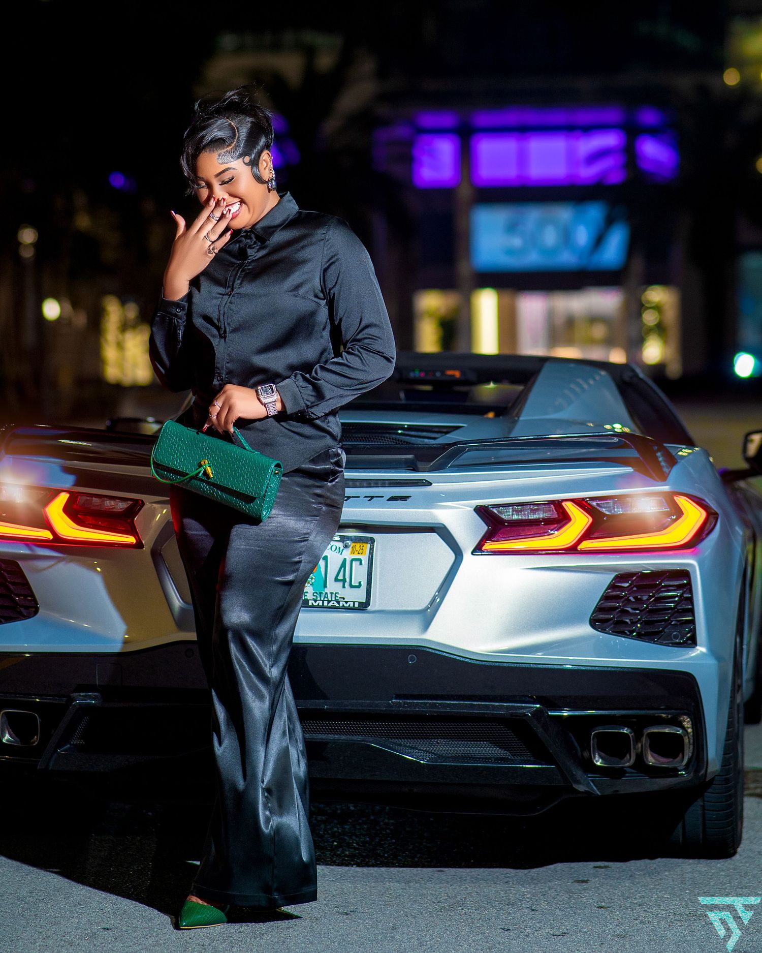 Sleek silver sports car with glowing LED taillights parked at night.