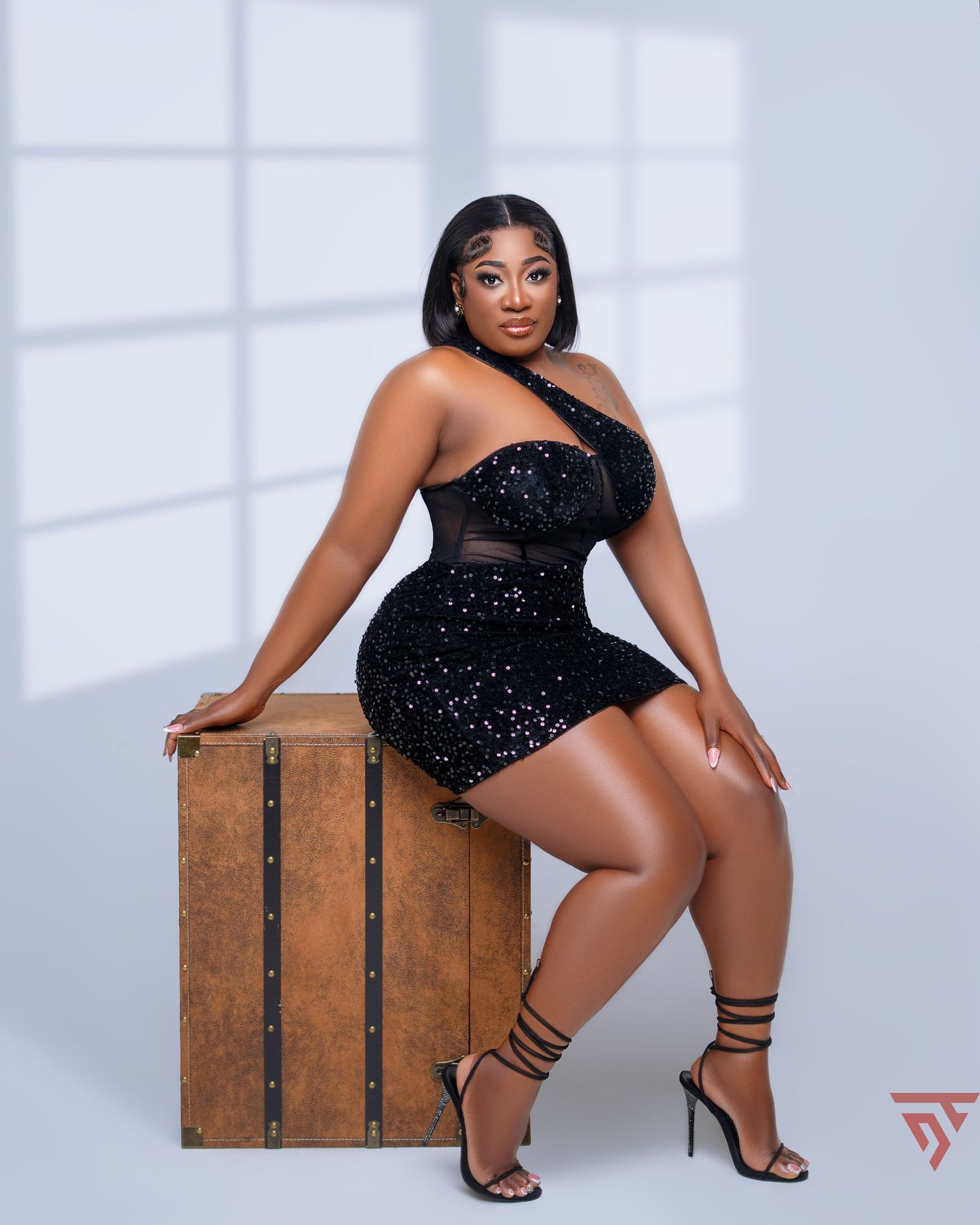 Modern glamour photography with wooden crate prop in studio setting.