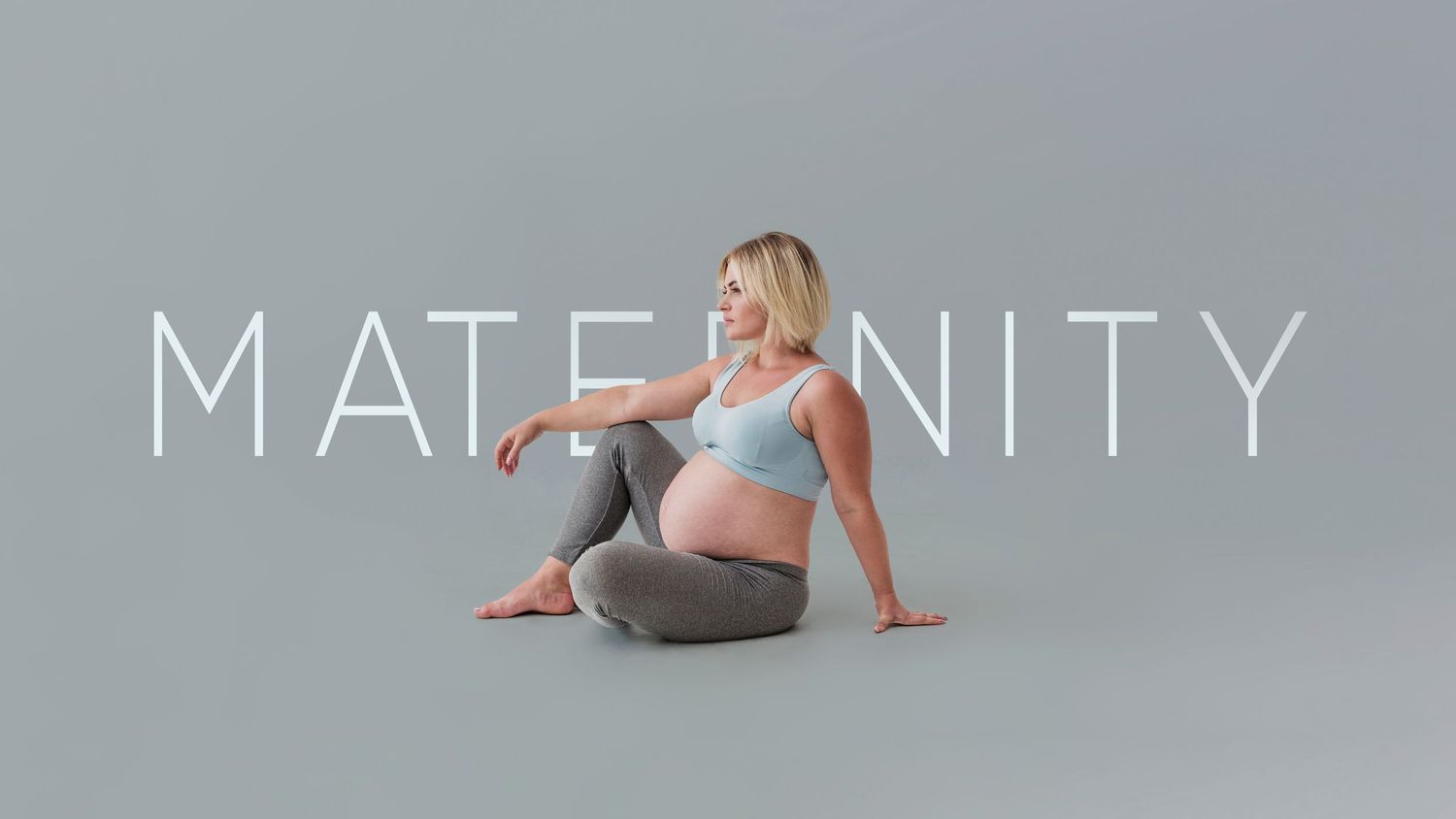 Minimalist maternity photography banner with text overlay against grey background.