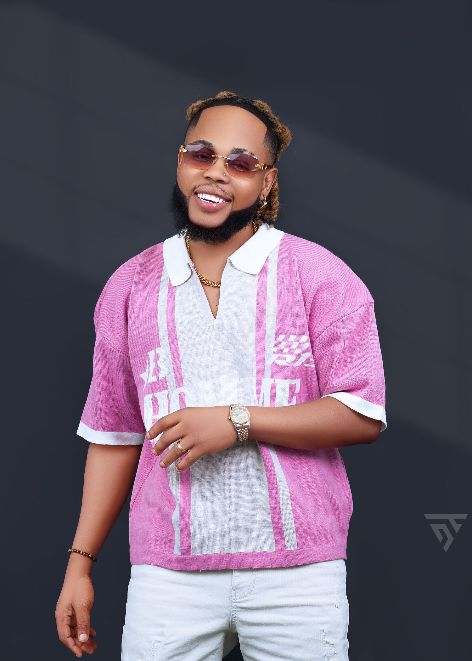 Casual portrait in pink and white striped polo shirt against dark background.