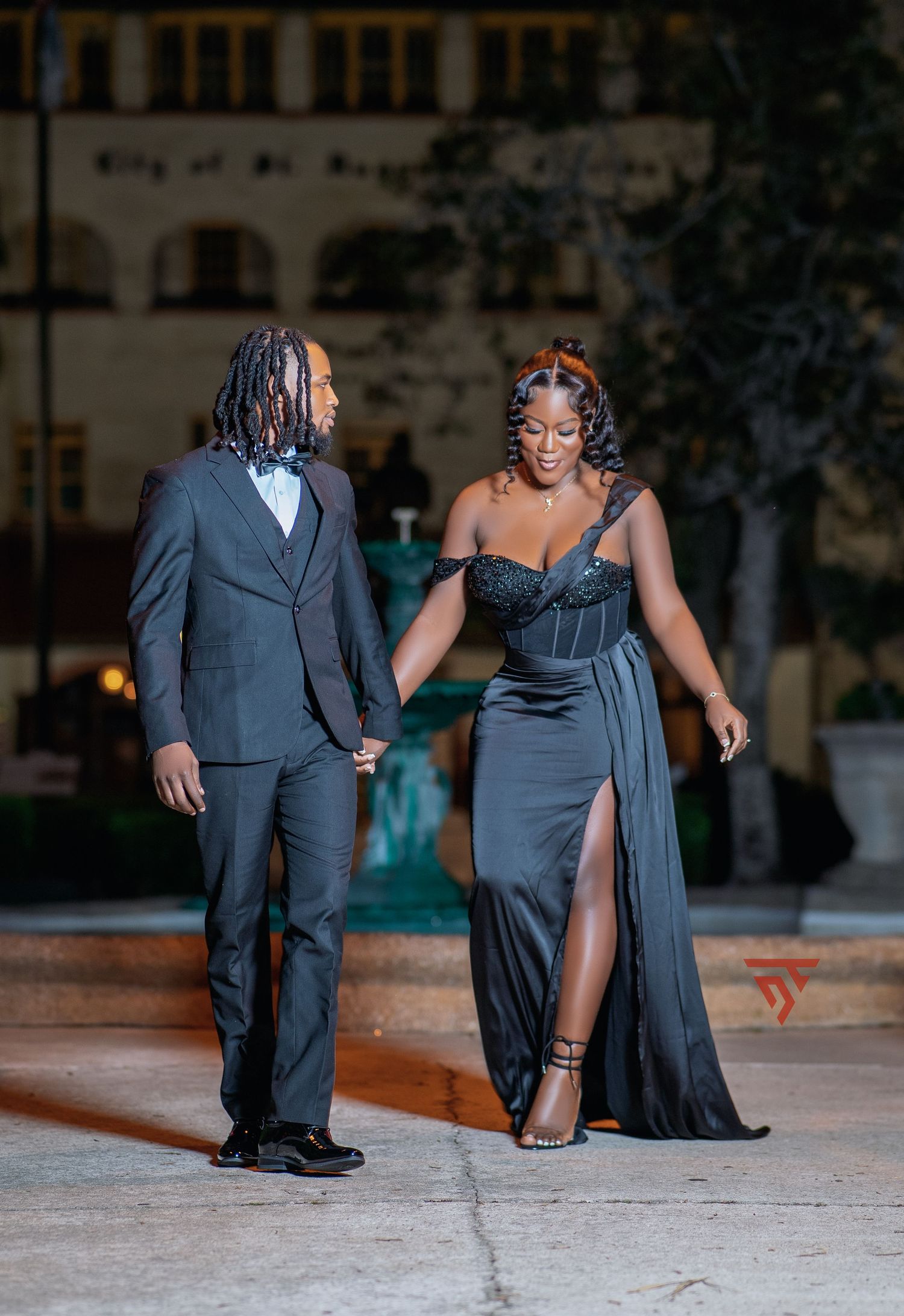 A couple in formal attire poses together for dramatic evening portraits.