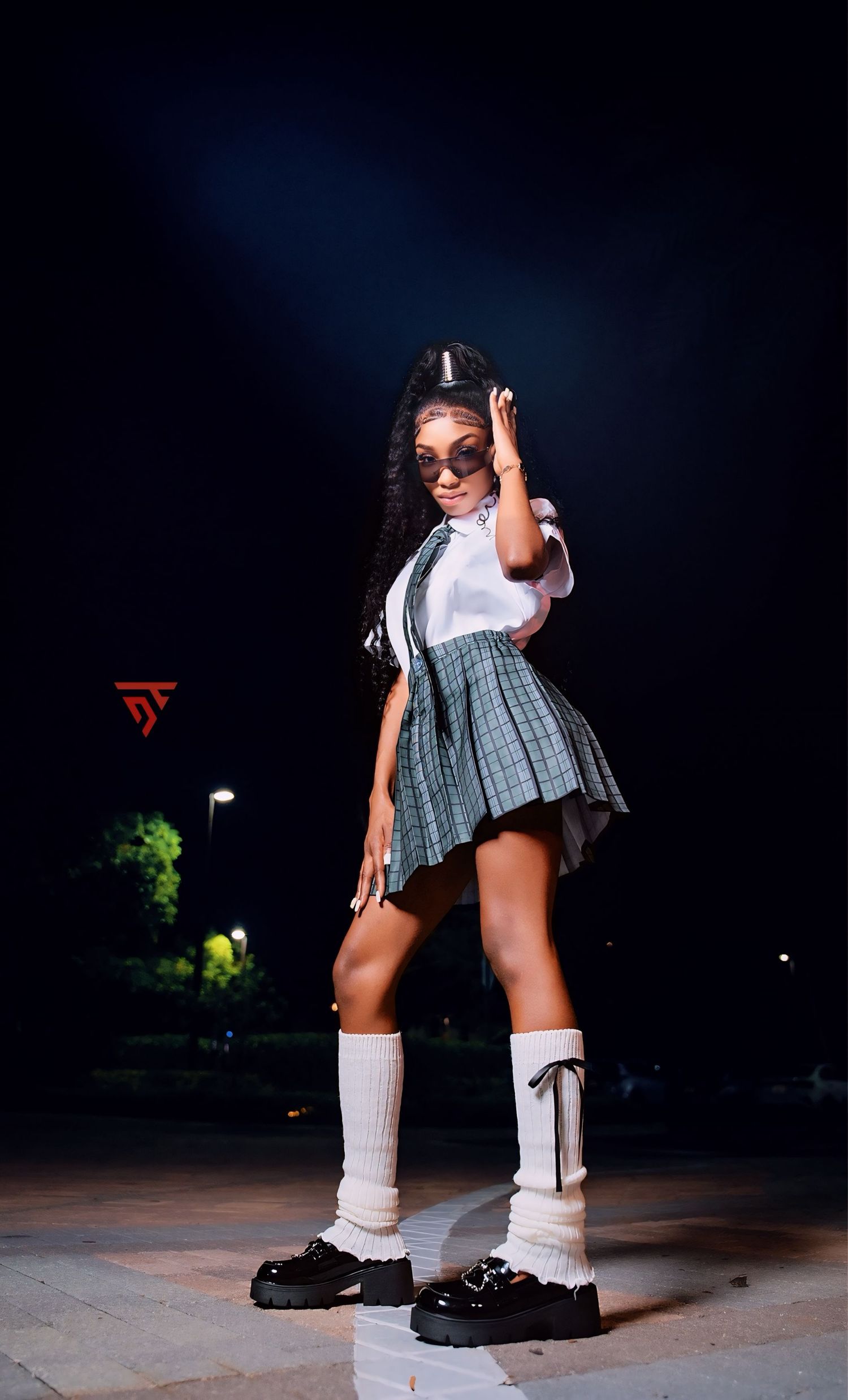 Preppy schoolgirl-inspired outfit with pleated skirt and knee-high socks.