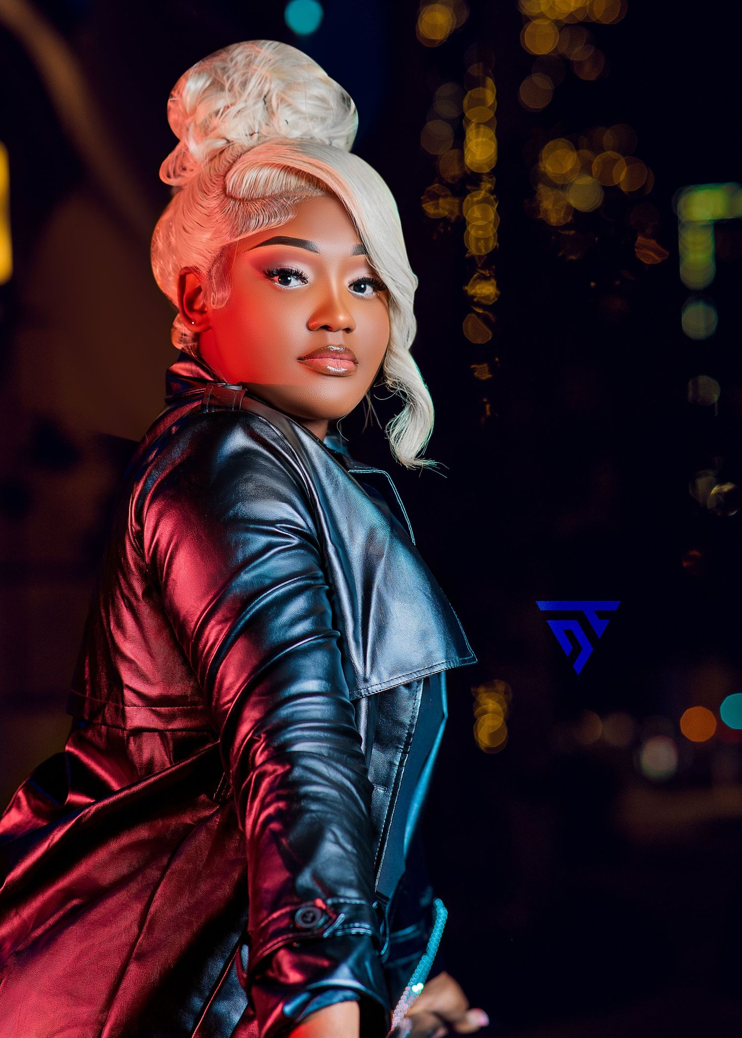Dramatic night portrait in leather jacket with styled white-blonde updo.