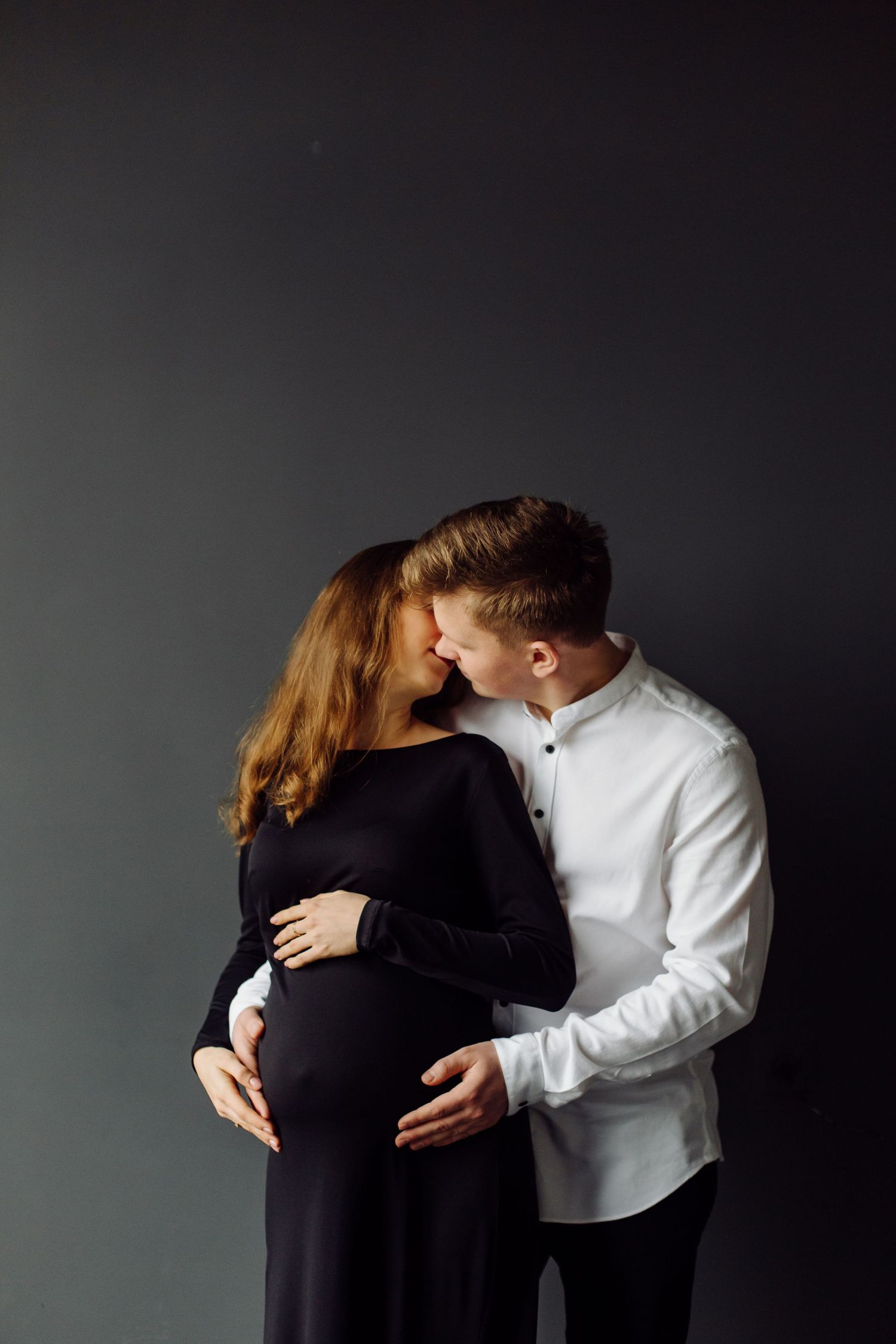 Artistic black and white maternity photos against dark background.