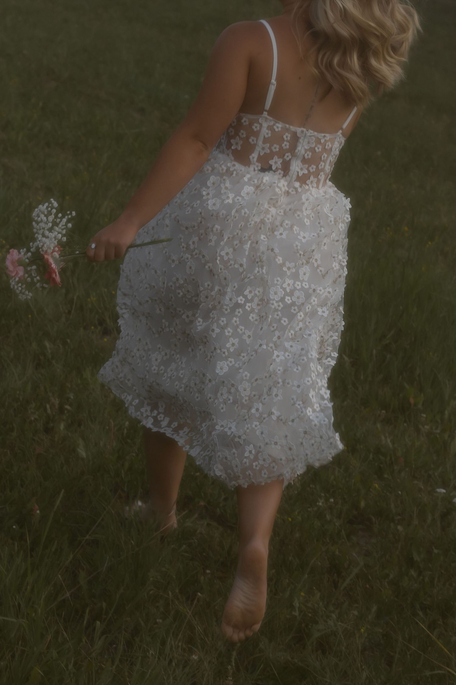 White tulle dress swishing in motion against a grassy background.