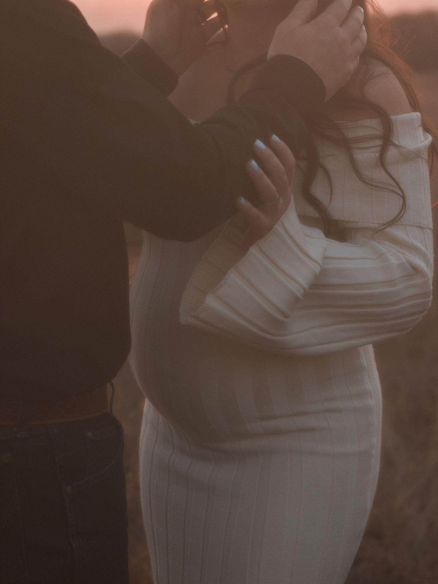 A maternity photo sequence showing a woman in a white dress against a warm sunset background.