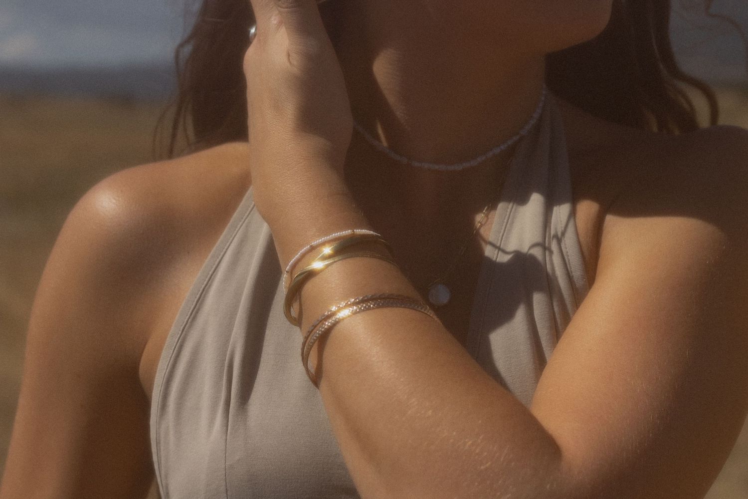 Close-up shot of hands and jewelry in warm sunlight.