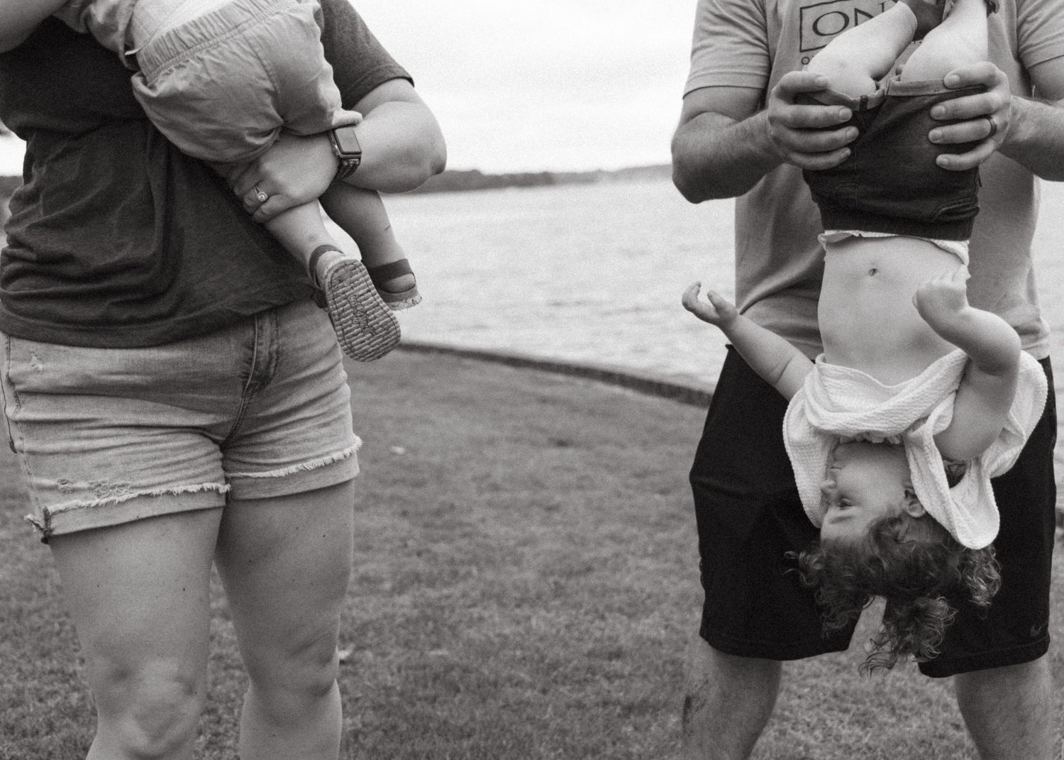 Adults and children playing together outdoors in black and white.