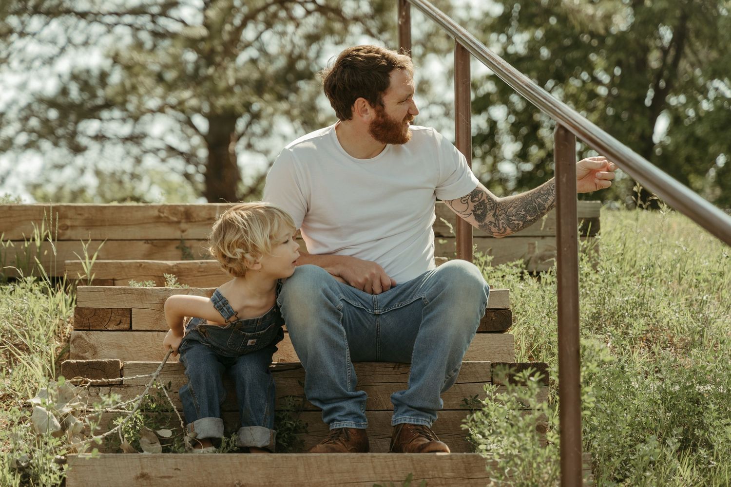 A family sits together on a rustic wooden bench in a park setting.