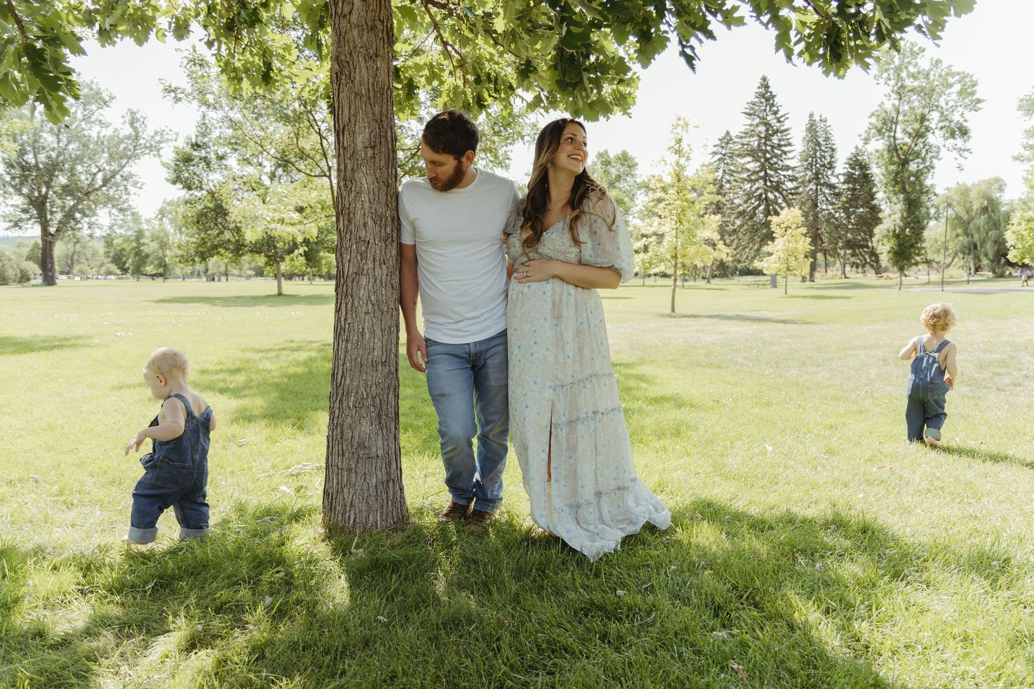 Joyful outdoor family photography session in a green park landscape.
