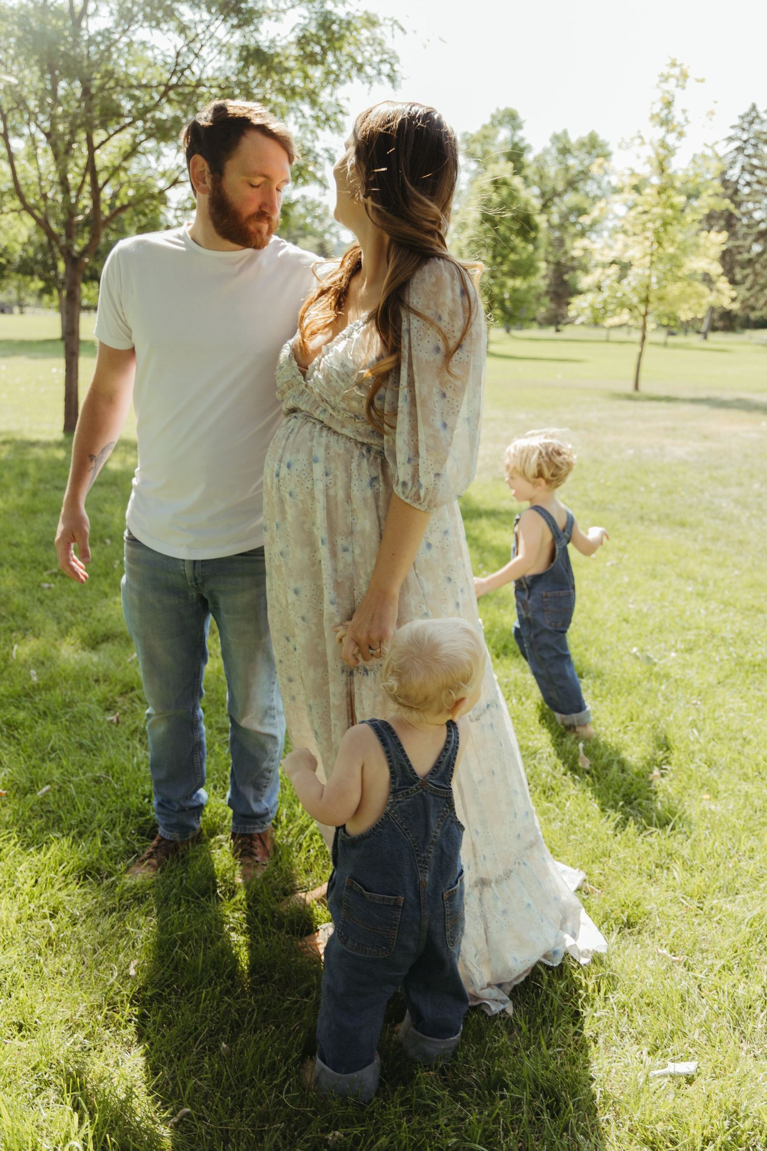 Candid family moments captured in a sunlit park setting.