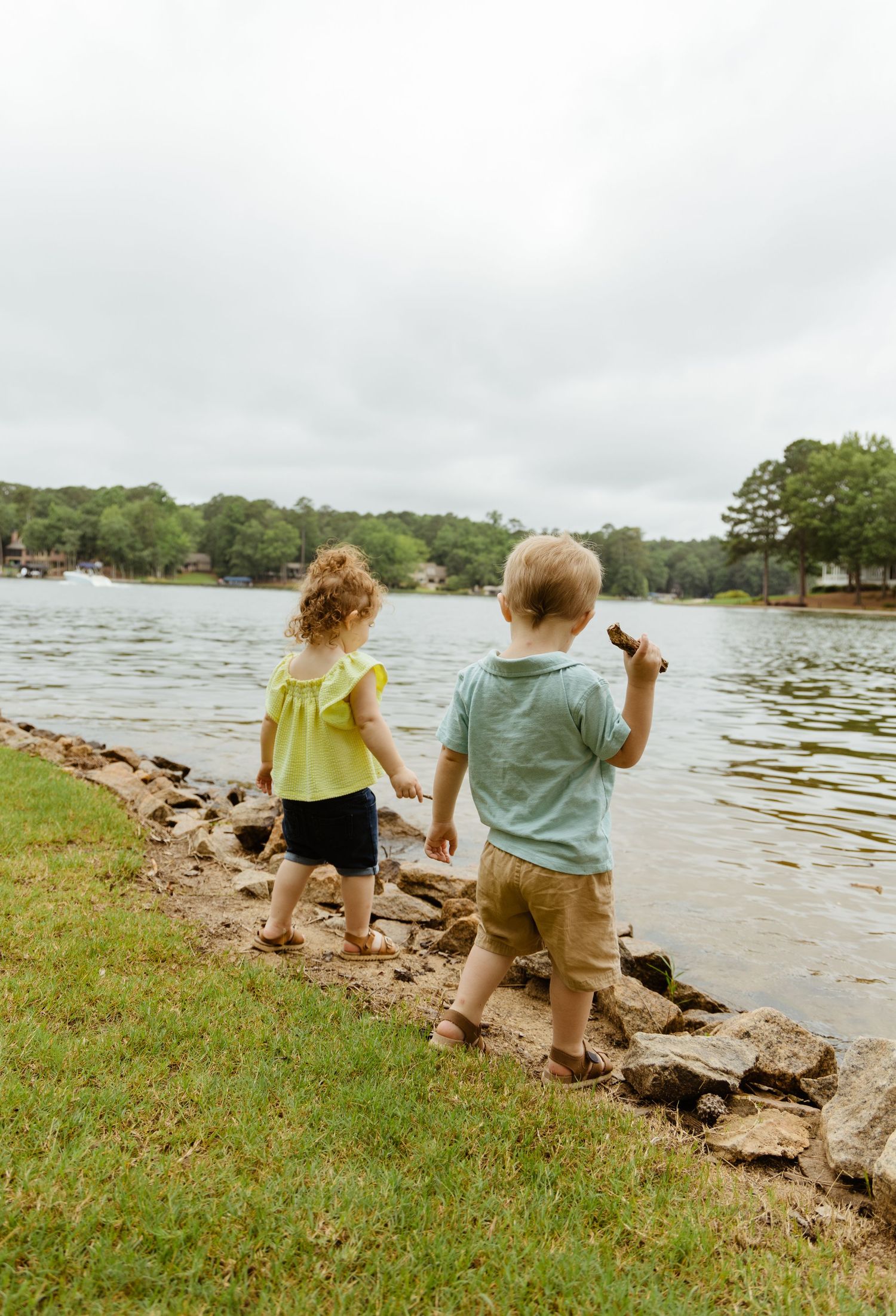 Kids throwing rocks in lake photography