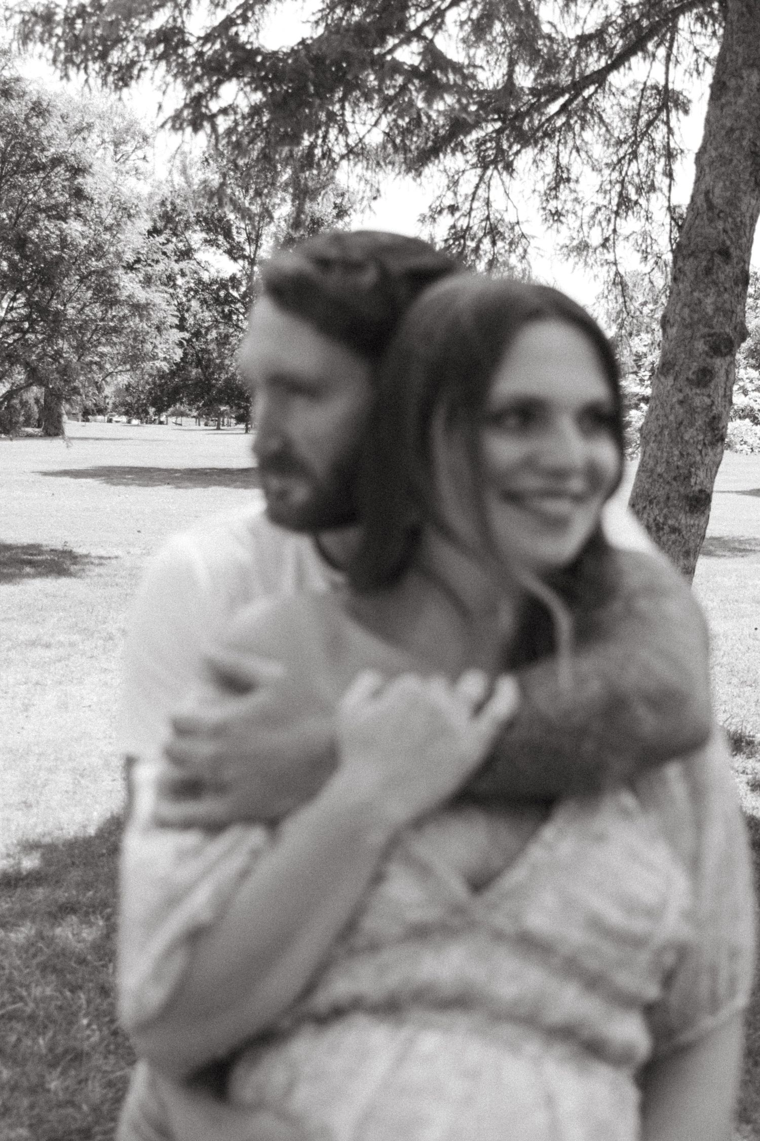 Black and white maternity portraits captured under shady trees.