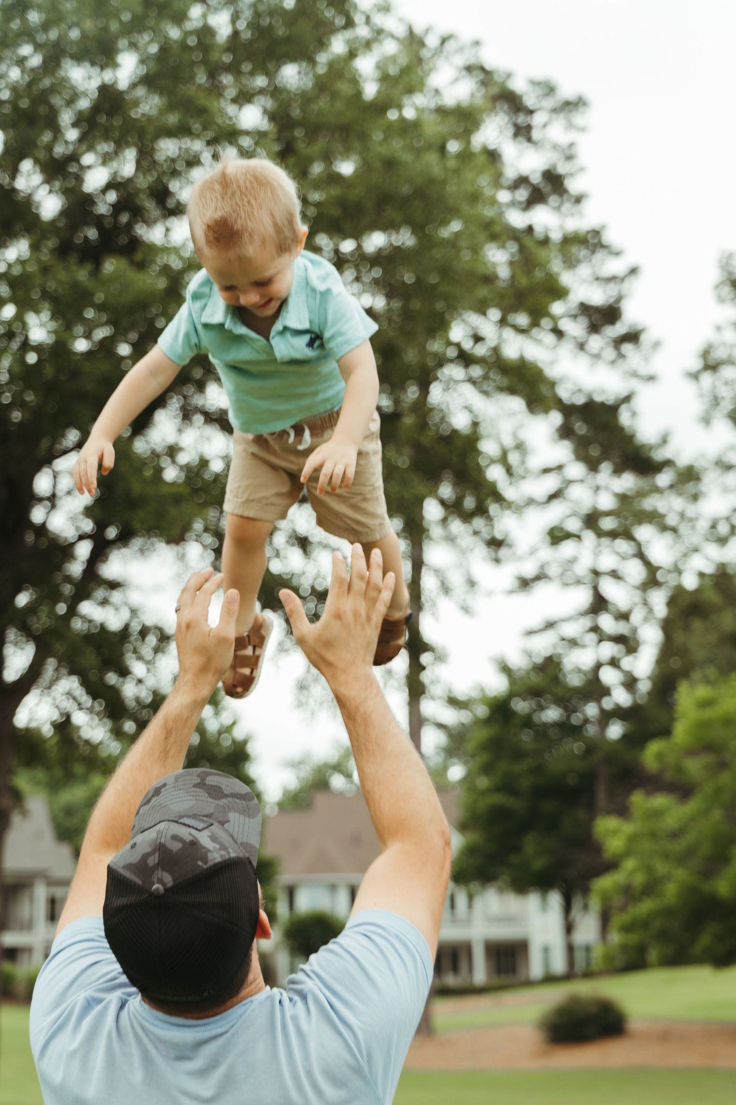 Joyful moment of a child being tossed in the air on a sunny day.
